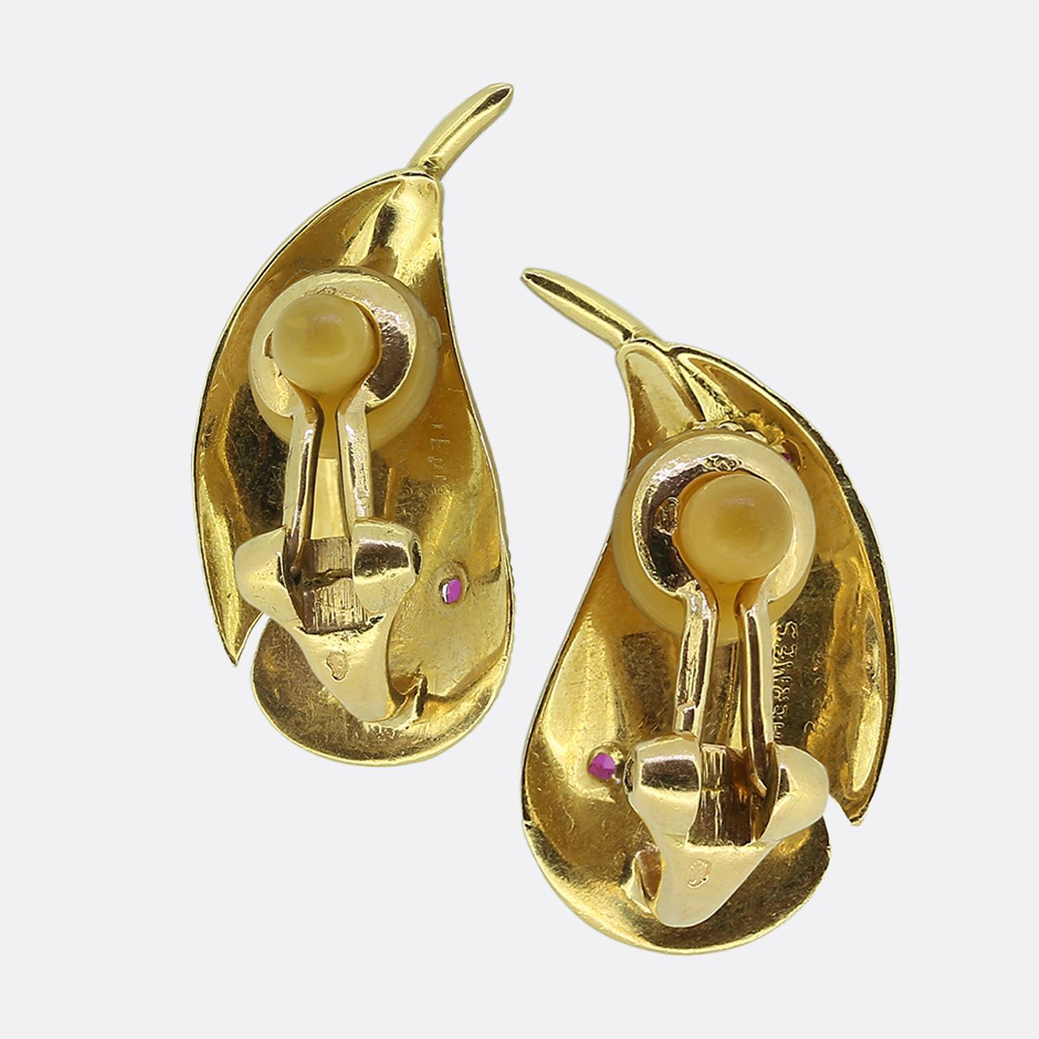 Ecco uno splendido paio di orecchini del famoso stilista Hermès. Ogni pezzo identico è stato meticolosamente realizzato in oro giallo 18 carati a forma di piuma delicata e presenta dettagli intricati che imitano la struttura naturale. All'interno