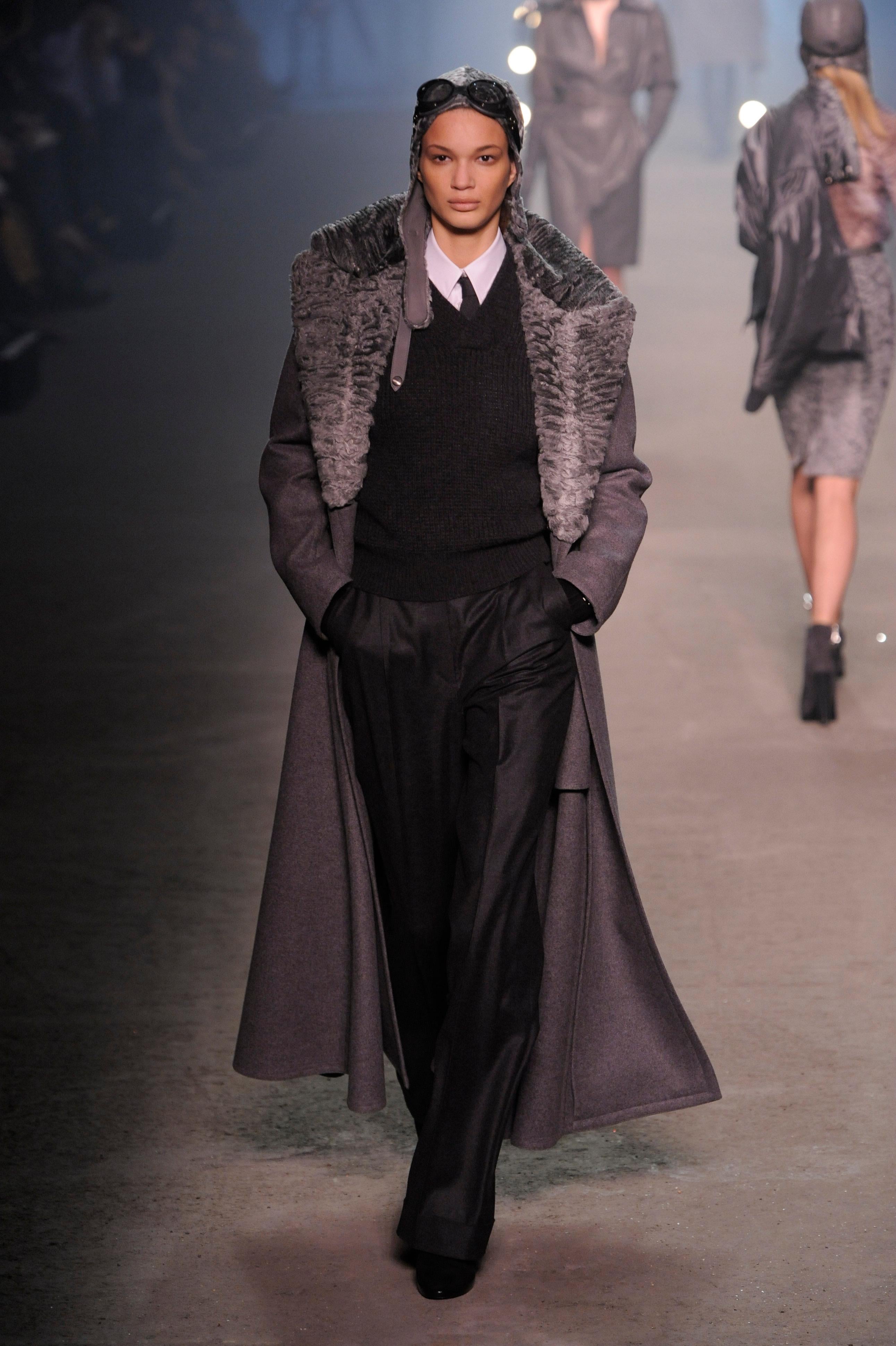 Hermès by Jean Paul Gaultier Autumn/Winter 2009 manteau long en cachemire double face gris avec col astrakan détachable.

Présenté sur le podium et dans la campagne. Cette saison a été fortement inspirée par Amelia Earhart.

Taille étiquetée
