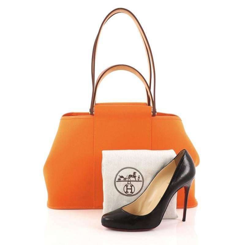 This authentic Hermes Cabag Elan Toile and Leather 39 is perfect for everyday use. Crafted in orange toile officier canvas with beige vache hunter leather trims, this lightweight tote features short handles and long straps, a sturdy rod, side snap