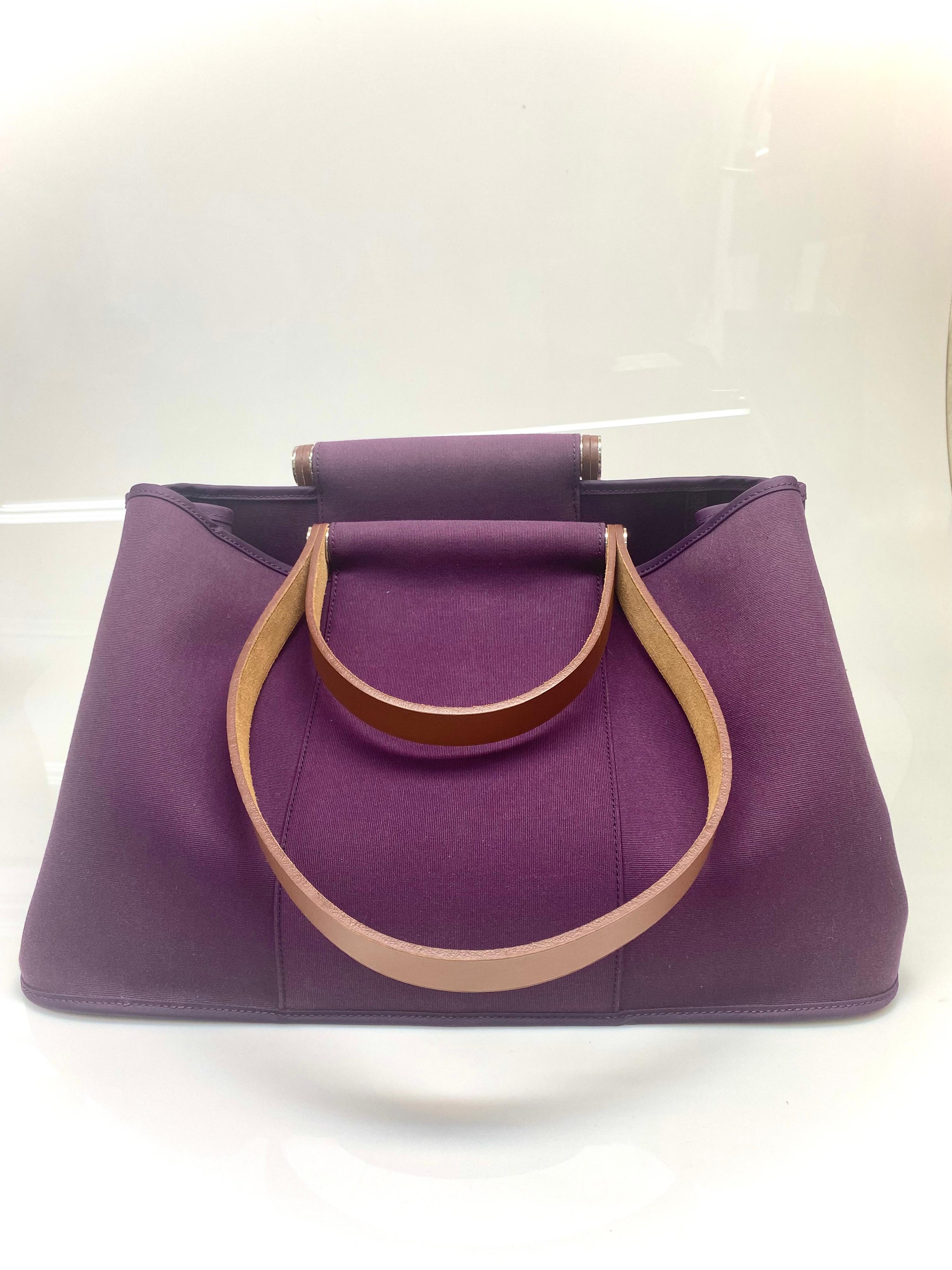 The Hermes Cabag is a simple & elegant tote that is perfect for everyday luxury. The fuchsia-colored canvas exterior is complemented by hunter leather straps sets of short handles & longer handles to use a hand or shoulder bag. Inside are 2 hanging