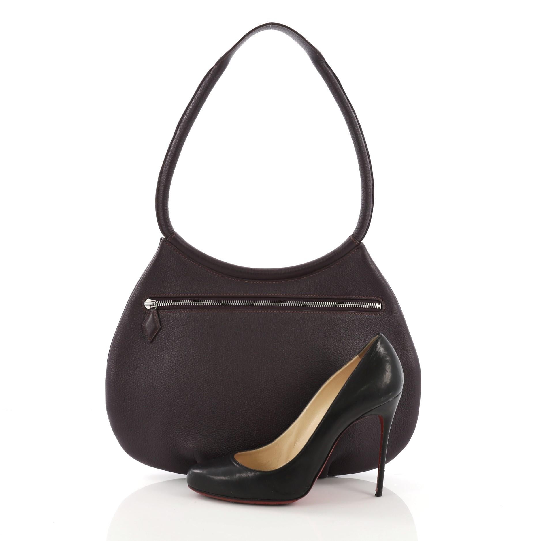 This Hermes Cacahuete Handbag Leather, crafted in Raisin purple Togo leather, features a rolled leather handle, pleated bottom and palladium hardware. Its zip closure opens to a Raisin purple Agneau leather interior. Date stamp reads: F Square