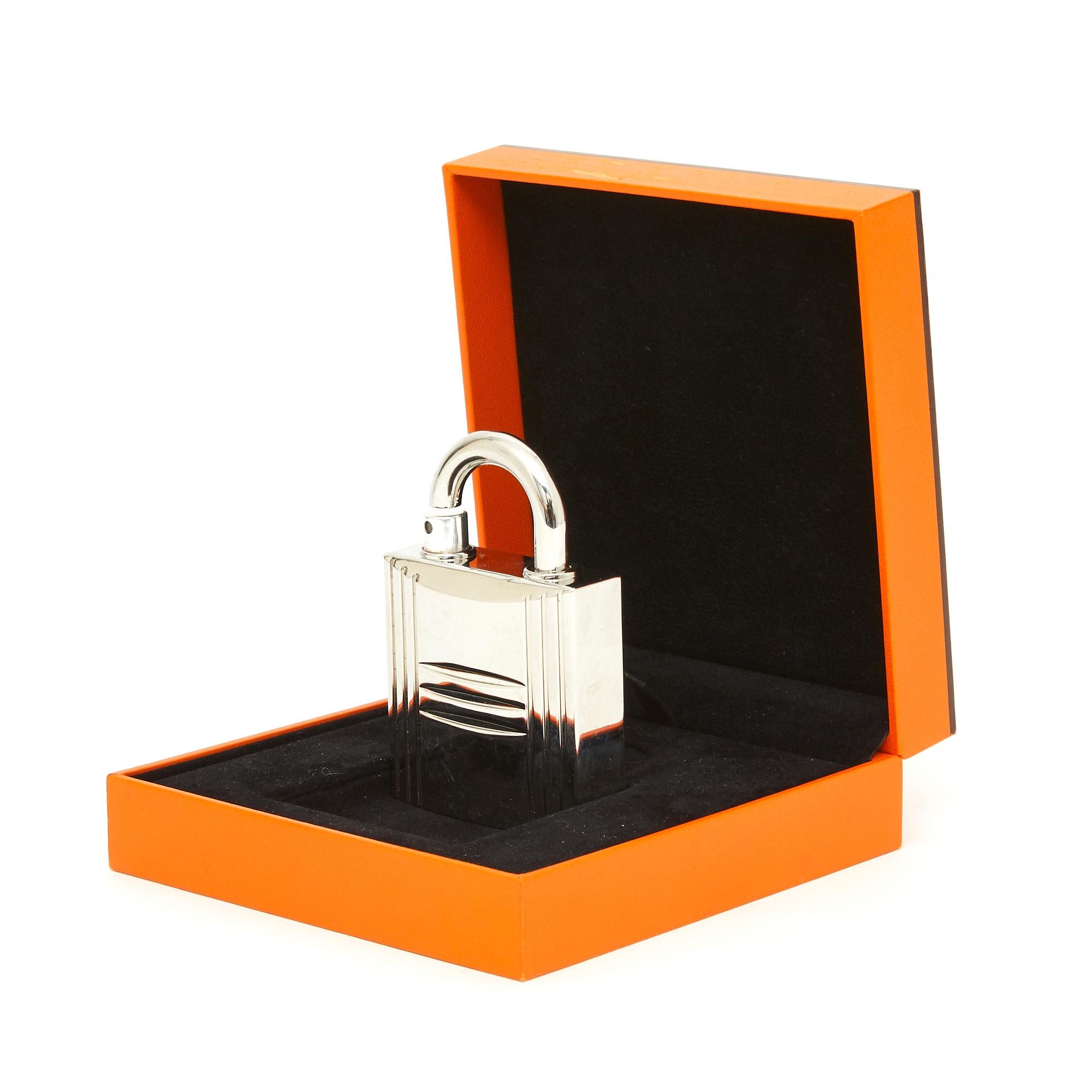 Hermès Kelly model bag spray, Kelly version (but it is the same for Calèche or 24 Faubourg) in silver metal with the Kelly bag padlock motif, delivered in its original box. The padlock measures approximately 8 x 5.5 cm. The metal has some scratches