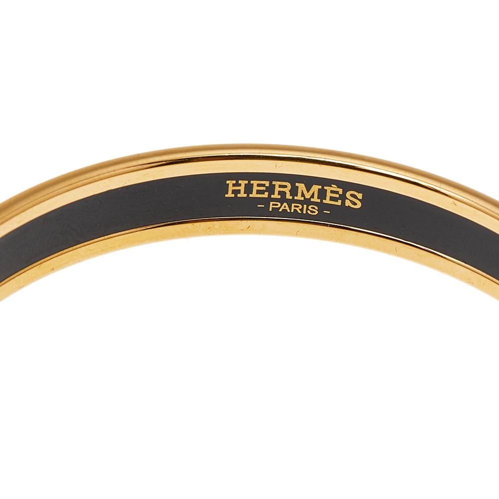 Beautify your wrist with this stunner of a bracelet from Hermes. The piece has been crafted from gold-plated metal and has an enamel coating on the exterior. This bracelet is complete with the iconic label on the inside of this bangle bracelet.

