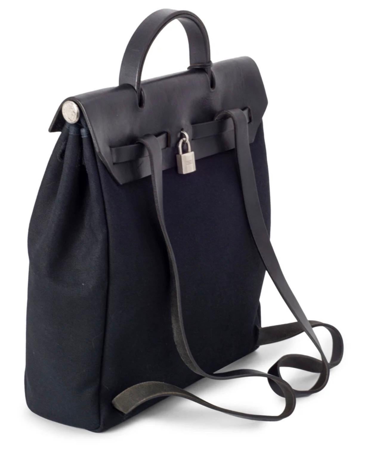Guaranteed Authentic Hermes Her Bag Backpack or 100% of your money back. This Hermes backpack is in black canvas leather. It features a lock closure and key. 

Measurements: 
Width 15.7 inch
Height 13.3 inch
Depth 4 inch
handle 8 inch
Shoulder 24.5