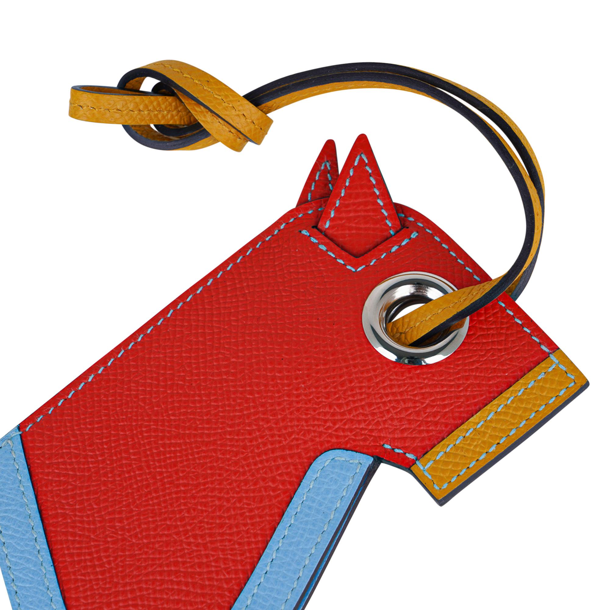 Mightychic offre une garantie d'authenticité du porte-clés Hermès Camail convoité dans Capucine,  Jaune Ambre et Bleu Celeste.
Une version moderne de la tête de cheval en cuir d'Epsom avec un porte-clés caché.
Charmante et enjouée, elle s'intègre