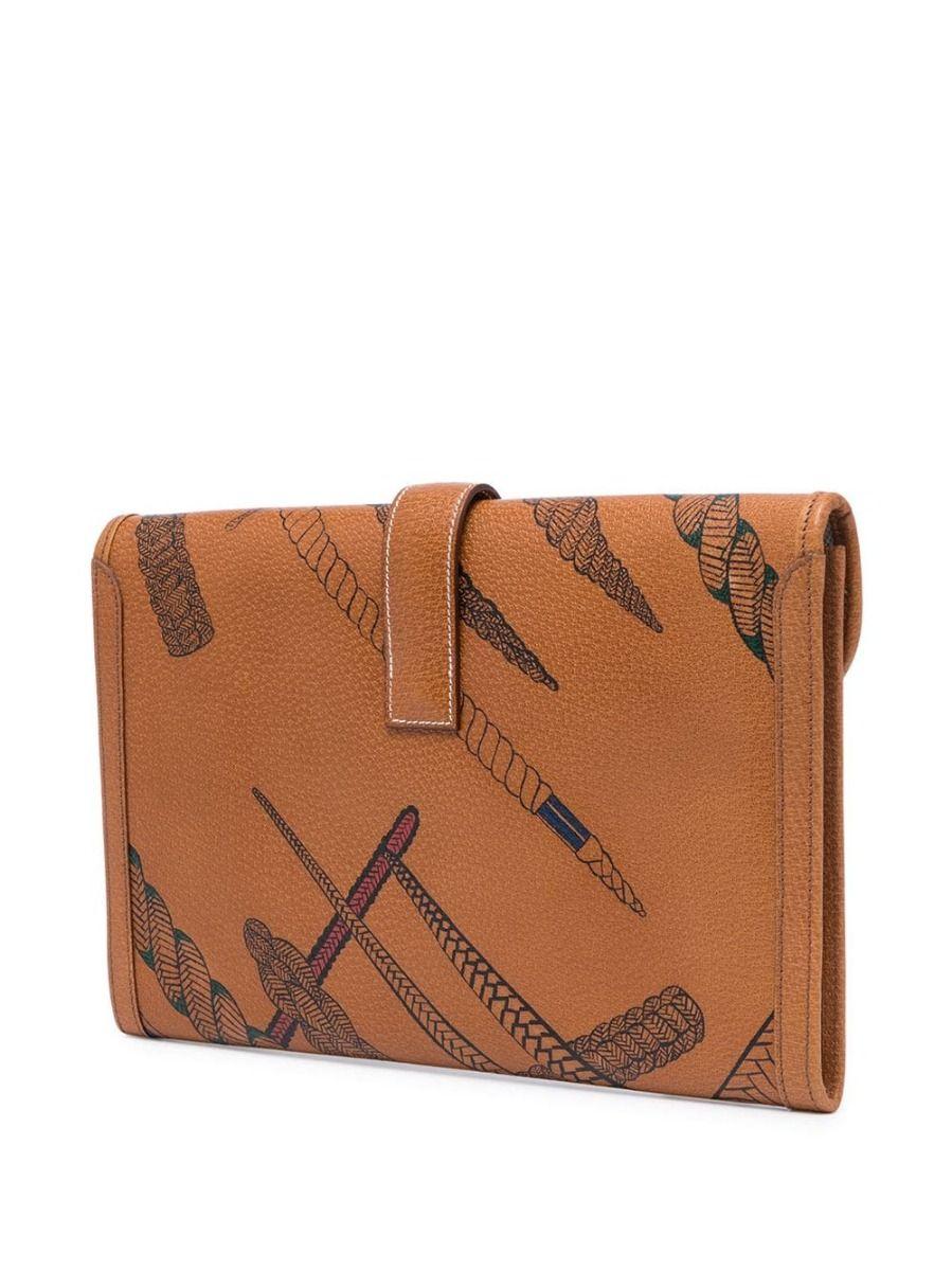 This Hermes Camel leather Jige clutch is like no other, customised with handpainted knot print all over the front and back of the iconic clutch. The equestrian-inspired print complements the Hermes style and history of the brand, making this Jige