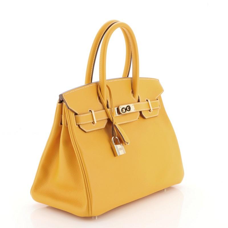 This Hermes Candy Birkin Handbag Epsom 30, crafted from Jaune d'Or yellow Epsom leather, features dual rolled handles, front flap, and permabrass hardware. Its turn-lock closure opens to a Potiron orange Chevre leather interior with zip and slip
