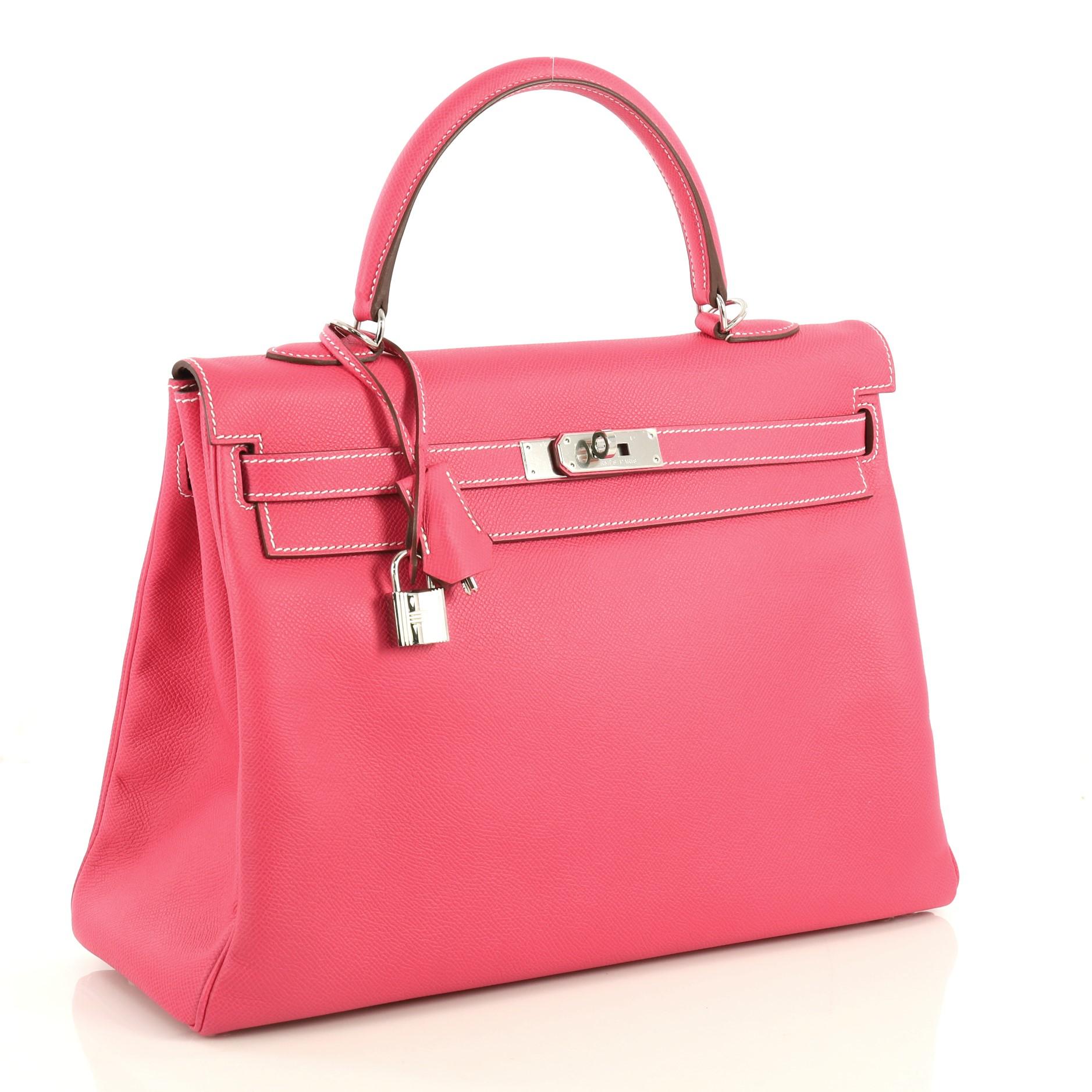 This Hermes Candy Kelly Handbag Epsom 35, crafted from Rose Tyrien pink Epsom leather, features a single rolled top handle, frontal flap, protective base studs, and palladium hardware. Its turn-lock closure opens to a Rubis Chevre leather interior