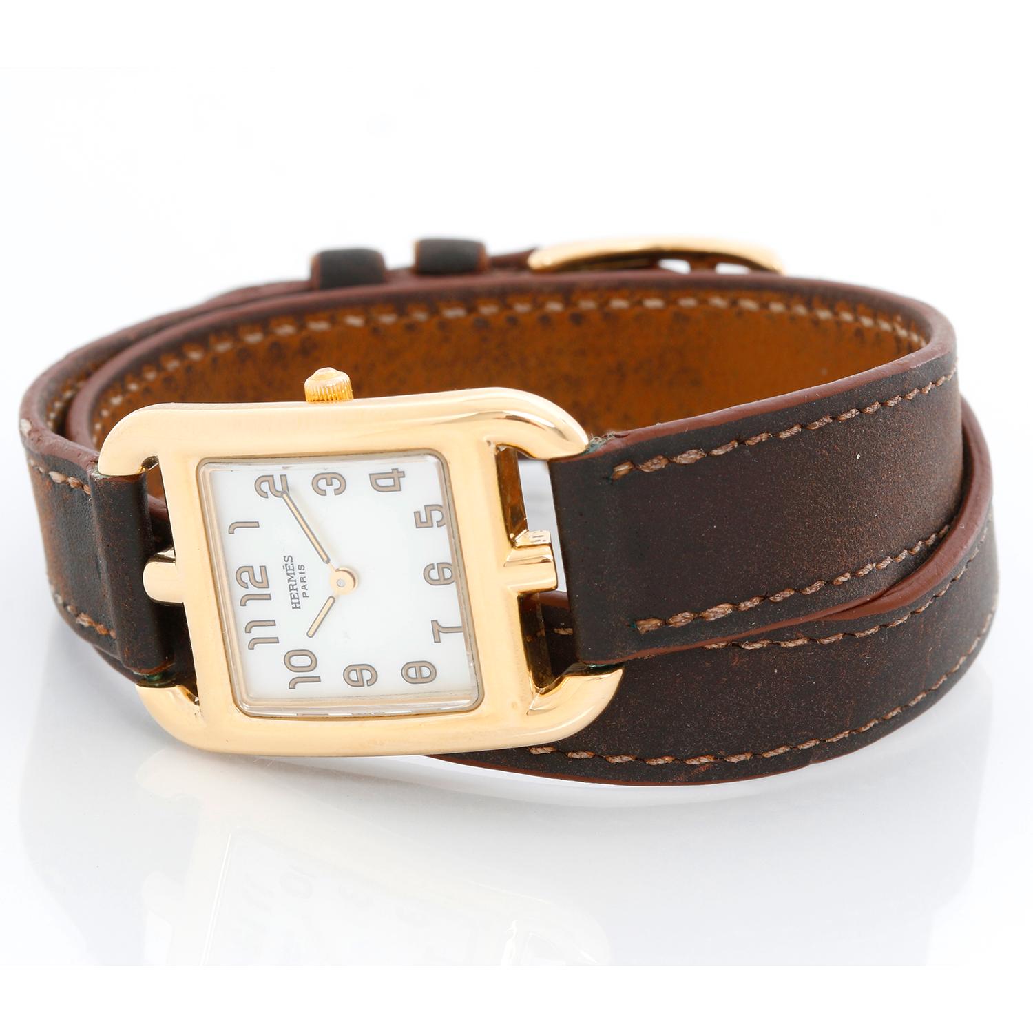 Hermes Cape Cod Yellow Gold Ladies  Watch - Quartz. 18K Yellow gold ( 23 x 34 mm ) . White mother of pearl watch with Arabic numerals . Double wrap calf skin brown strap with tang buckle . Pre-owned with custom box .