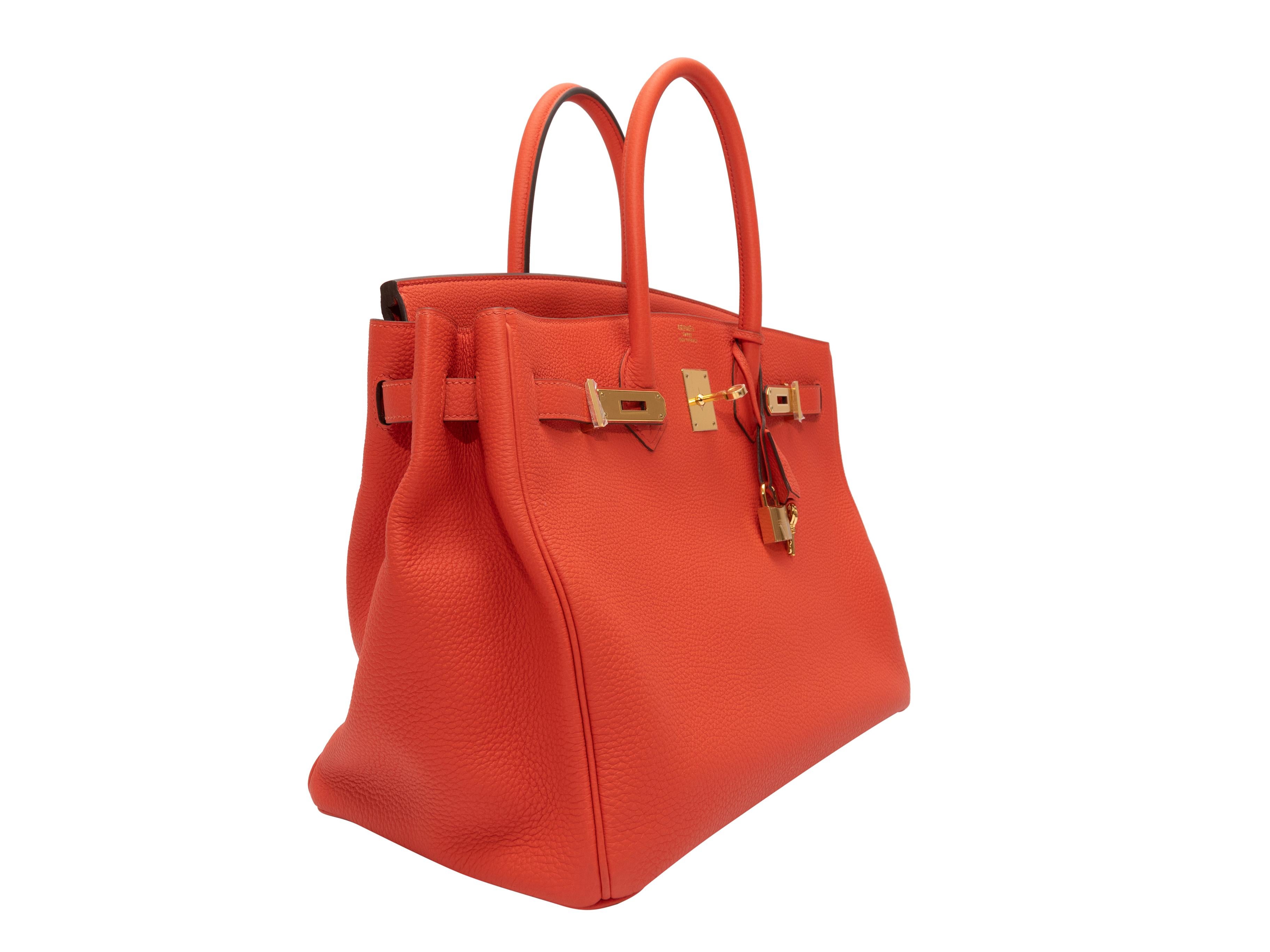 Product Details: Capucine Hermes Togo 35 Birkin Bag. The Togo 35 Birkin bag tote features a leather body, gold-tone hardware, dual rolled top handles, and a front lock closure. 13
