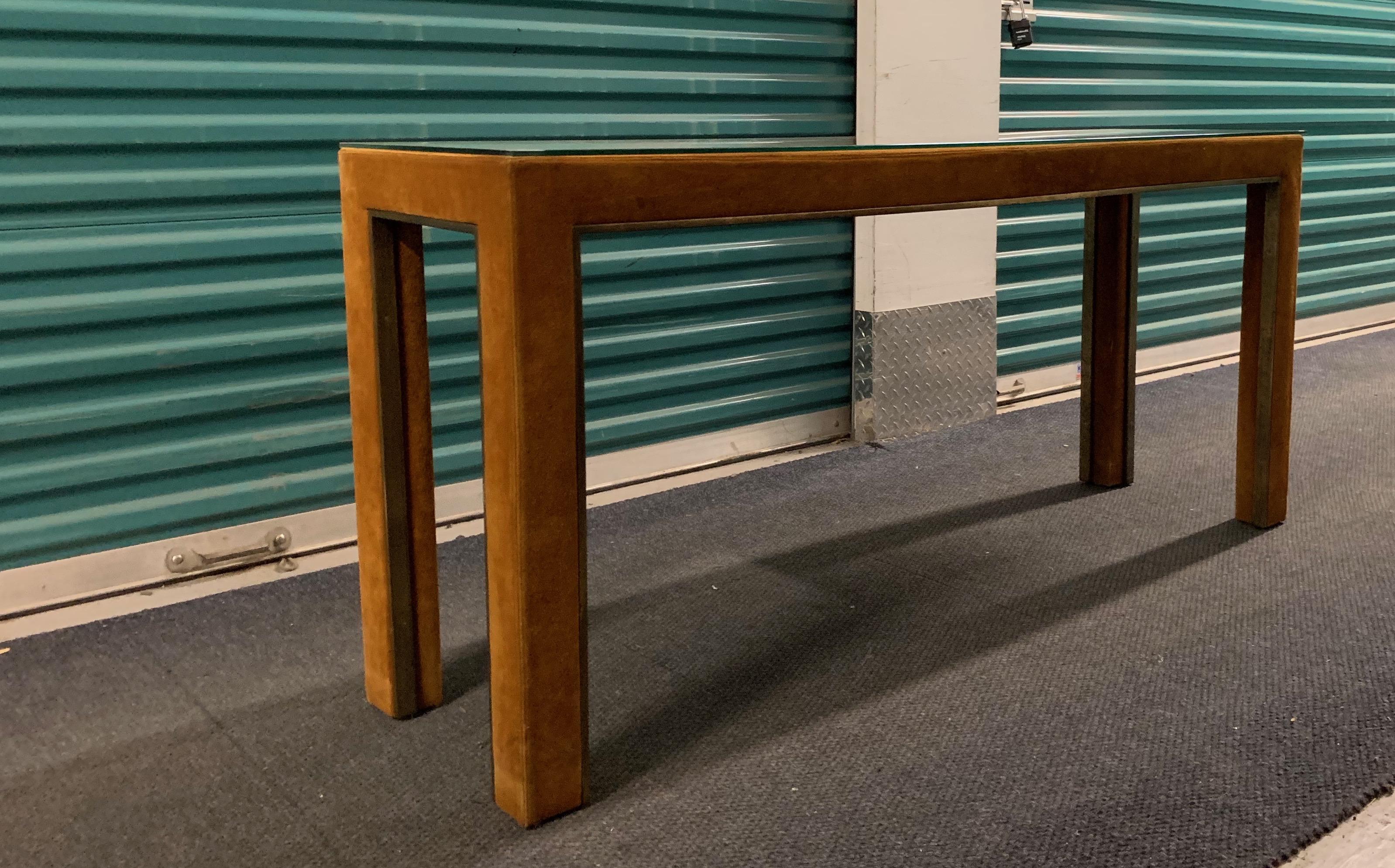 Caramel suede and bronze console table by Guido Faleschini i4 Mariani for Pace. Retailed by Hermès at select locations, 1970s. Table completely covered in suede with thin bronze metal trim. Custom glass top. Measures: H 27.75 inches, W 60 inches, D