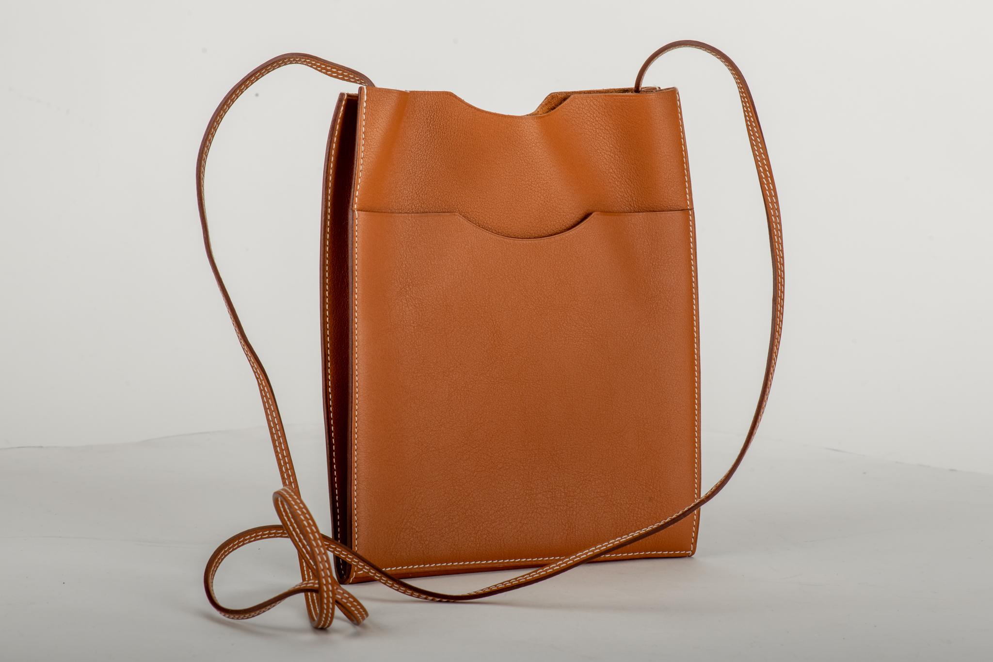 Hermès small crossbody bag in caramel swift leather with a back pocket. Comes with original dust cover. Minor wear on leather.