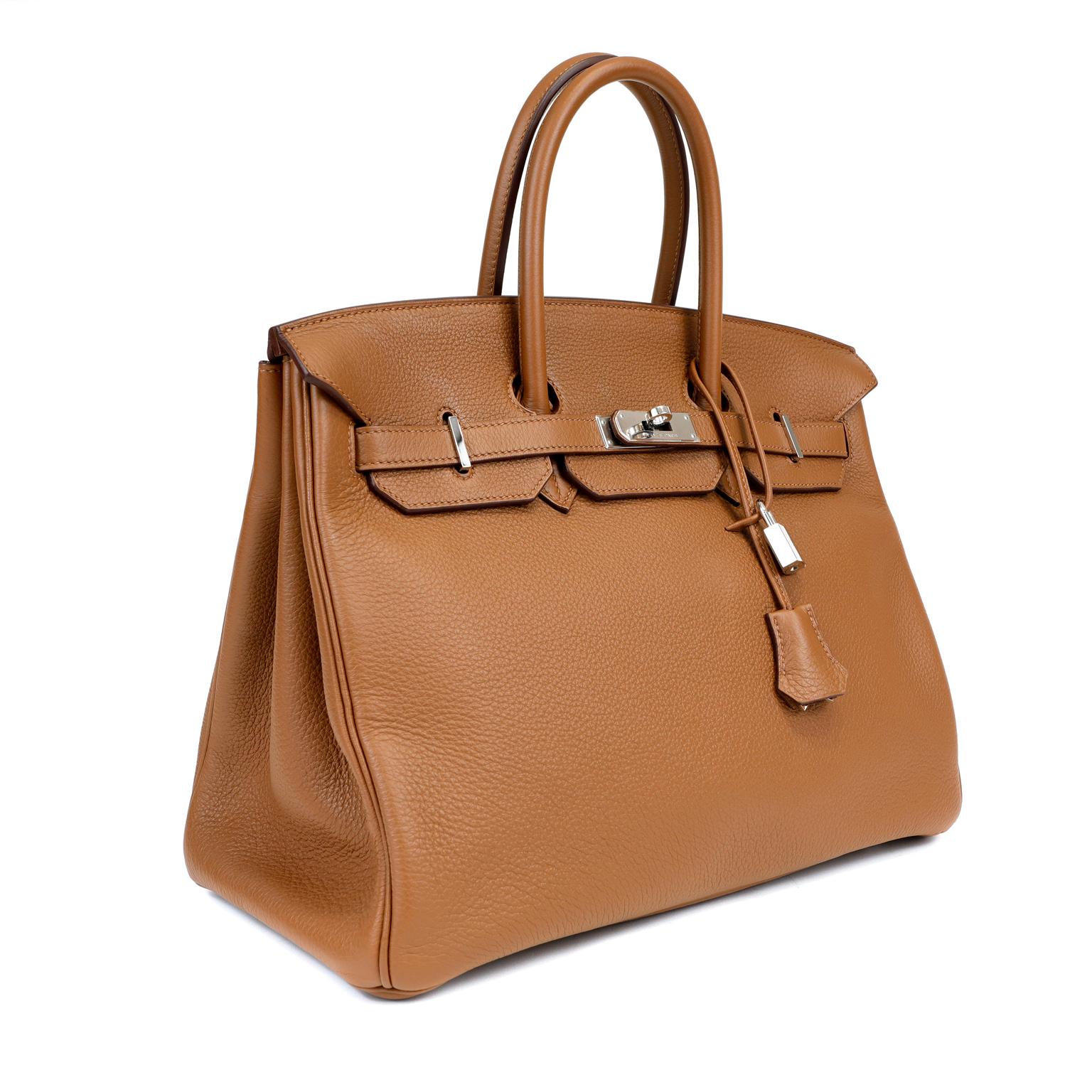 This authentic Hermès Caramel Togo 35 cm Birkin Bag is in pristine unworn condition with plastic intact on the hardware.  Waitlists exceeding a year are commonplace for the intensely coveted classic leather Birkin. Each piece is hand sewn by skilled