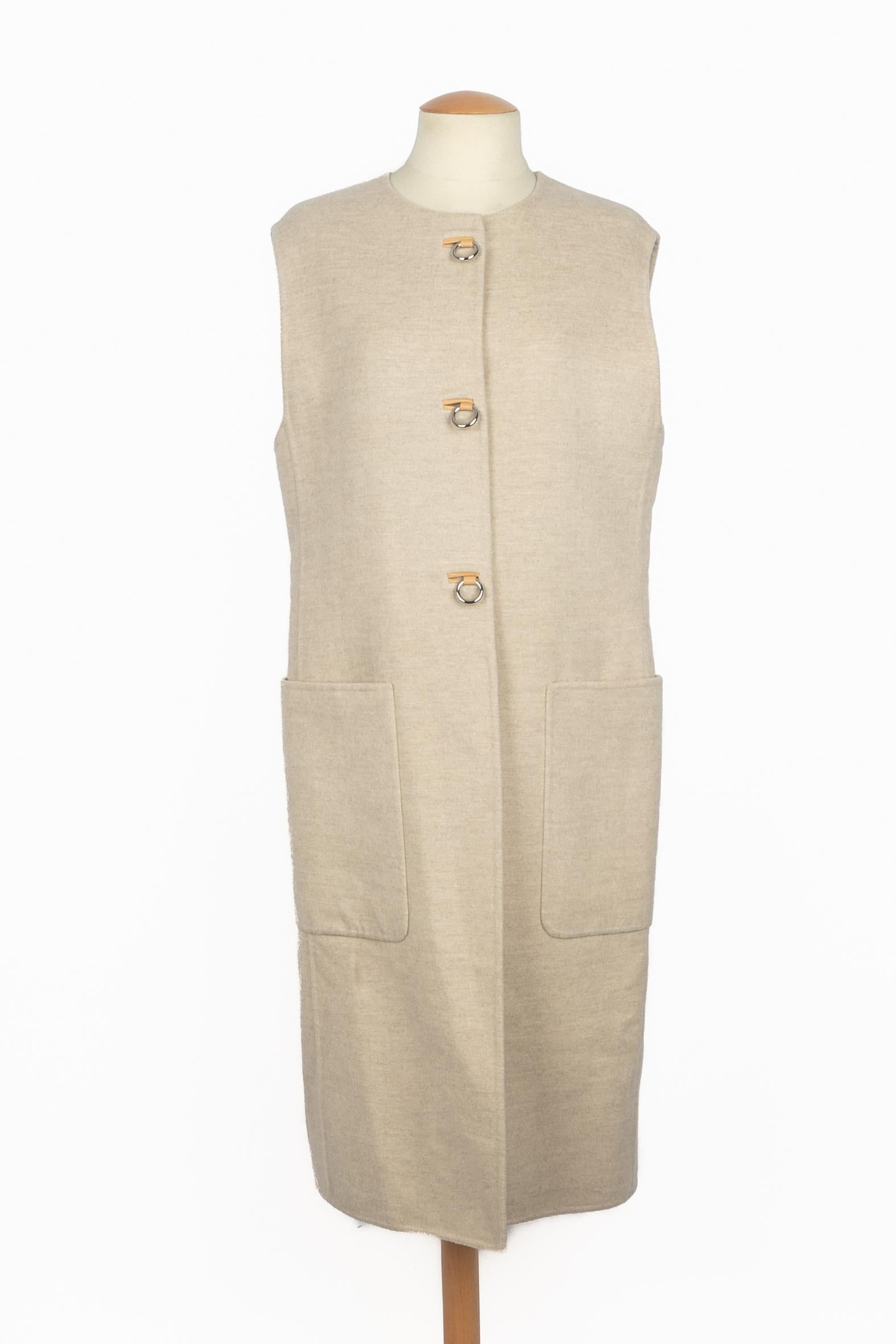 HERMÈS - (Fabriqué en France) Cardigan en cachemire beige avec boutons en cuir et boucle en métal argenté. Taille 40FR indiquée. Une Collection des années 2000 sous la Direction artistique de Martin Margiela.

Condit :
Très bon état.

Dimensions