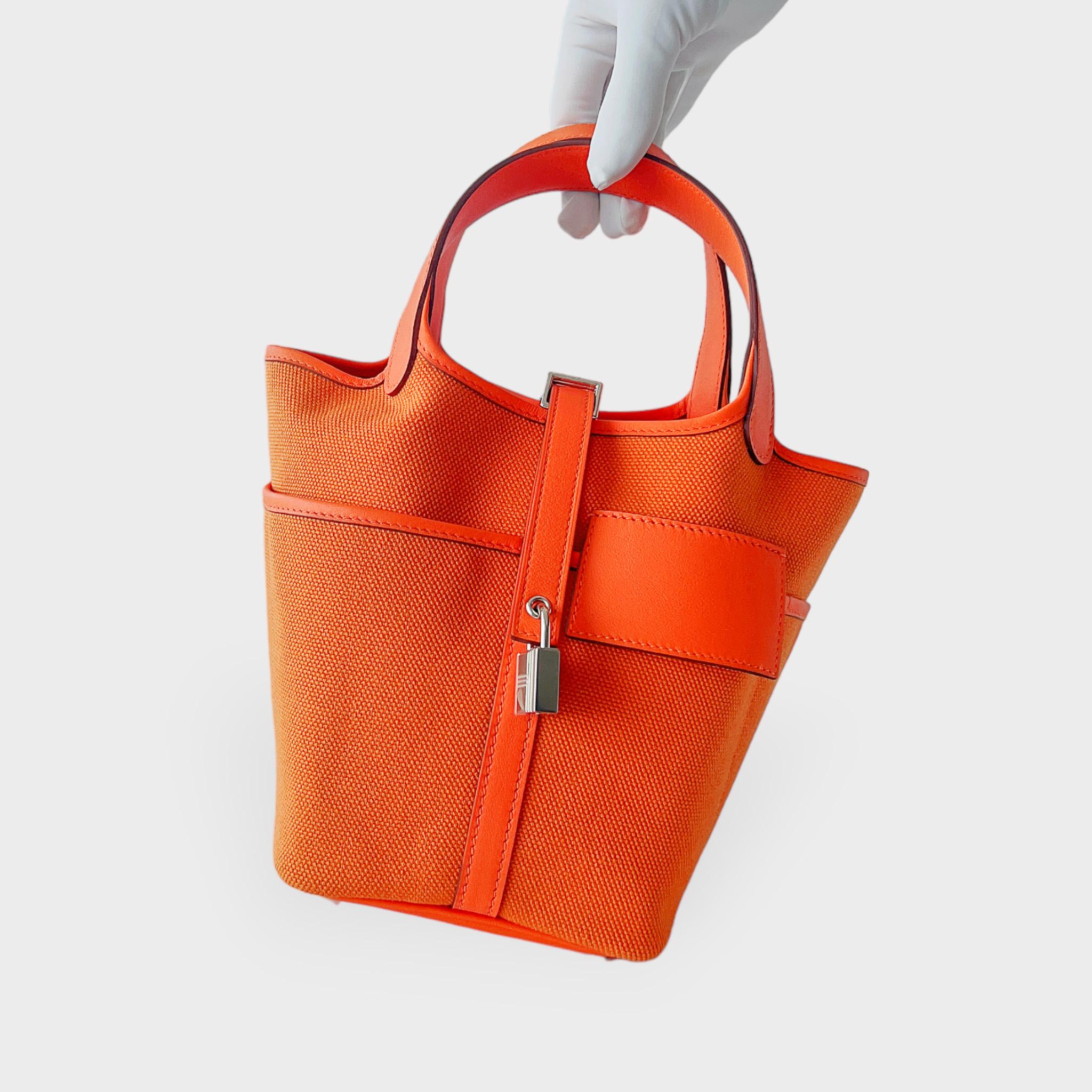 Shop this Hermes Cargo Picotin Lock Bag 18 In Orange With Palladium Plated Hardware which comes in the smaller Picotin size. This Picotin 18 comes in Orange Canvas detailing which is complimented to perfection with Palladium Plated Hardware. This