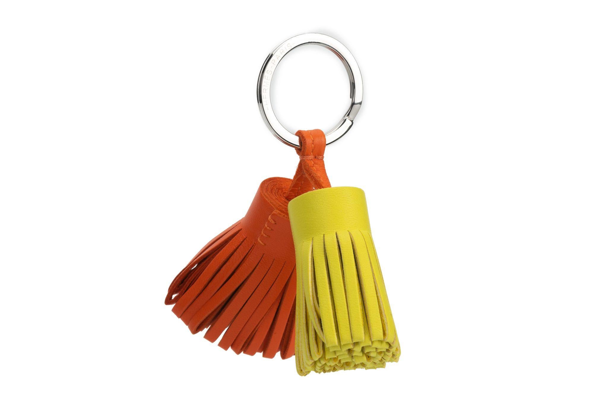 Hermès new double carmen keychain, lime and feu leather pom pom and palladium hardware. Comes with original box.