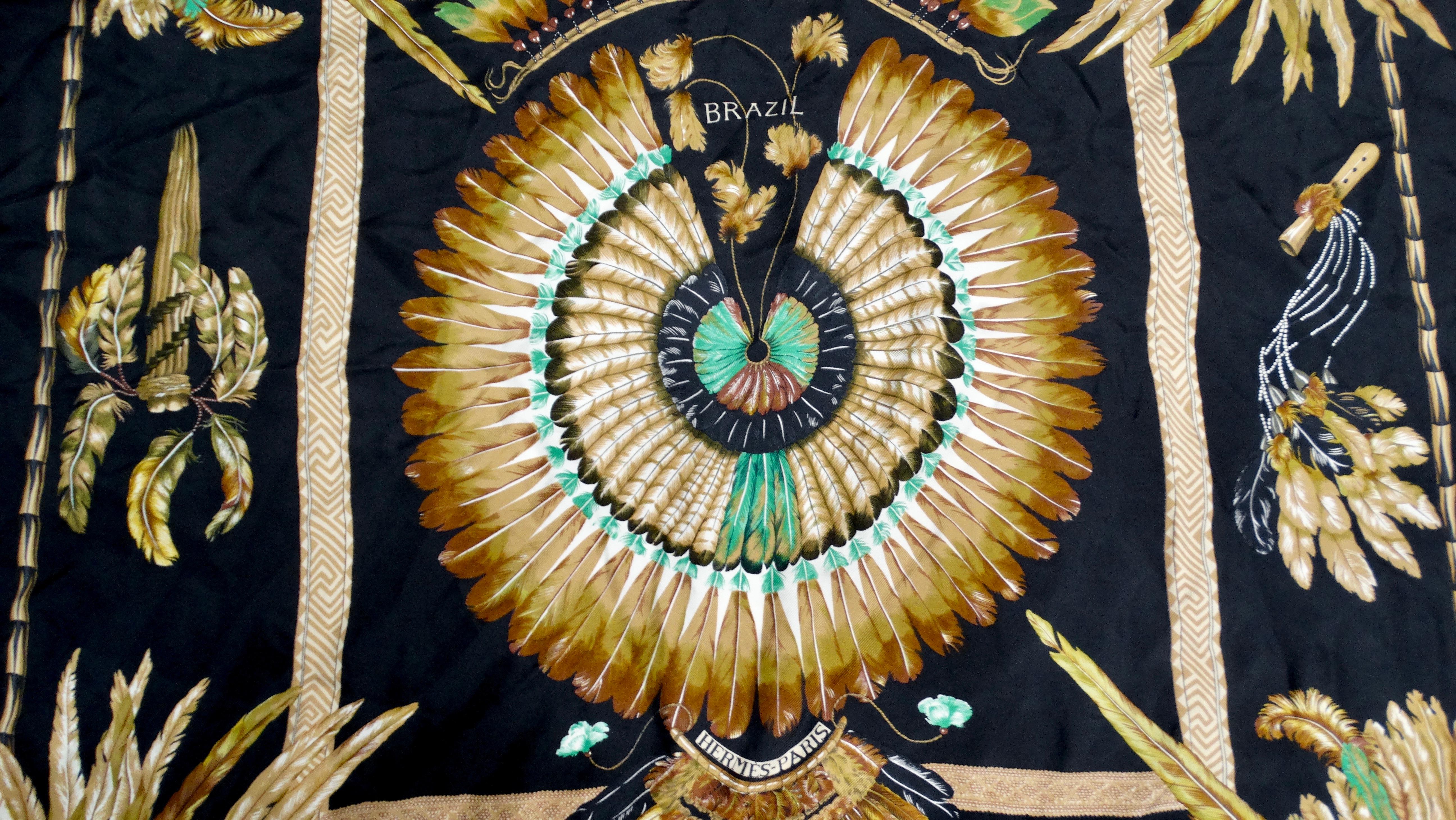 Embrace the allure of the exotic with the Hermes Carre 90 Brazil Feather Print Silk Scarf. Featuring a striking black base adorned with a vibrant feather tribal motif, this luxurious accessory encapsulates a sense of adventure and artistry, while