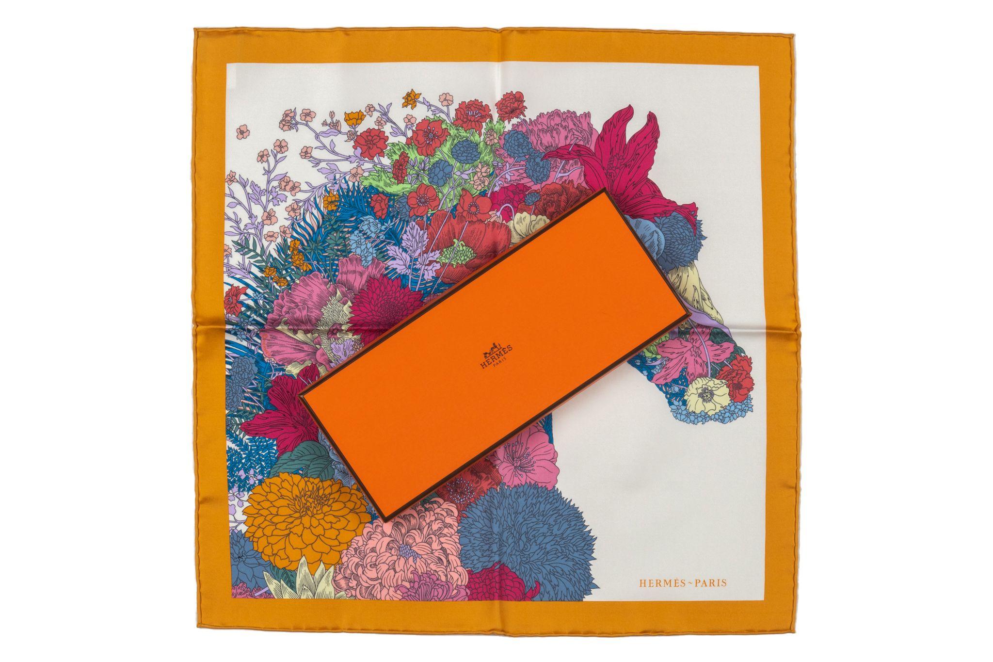 Hermes new Carré Gavroche Robe Regère with a orange frame and rolled edges. The print in the center is the head of a horse made of different flowers in multicolor. The piece comes with the original box.