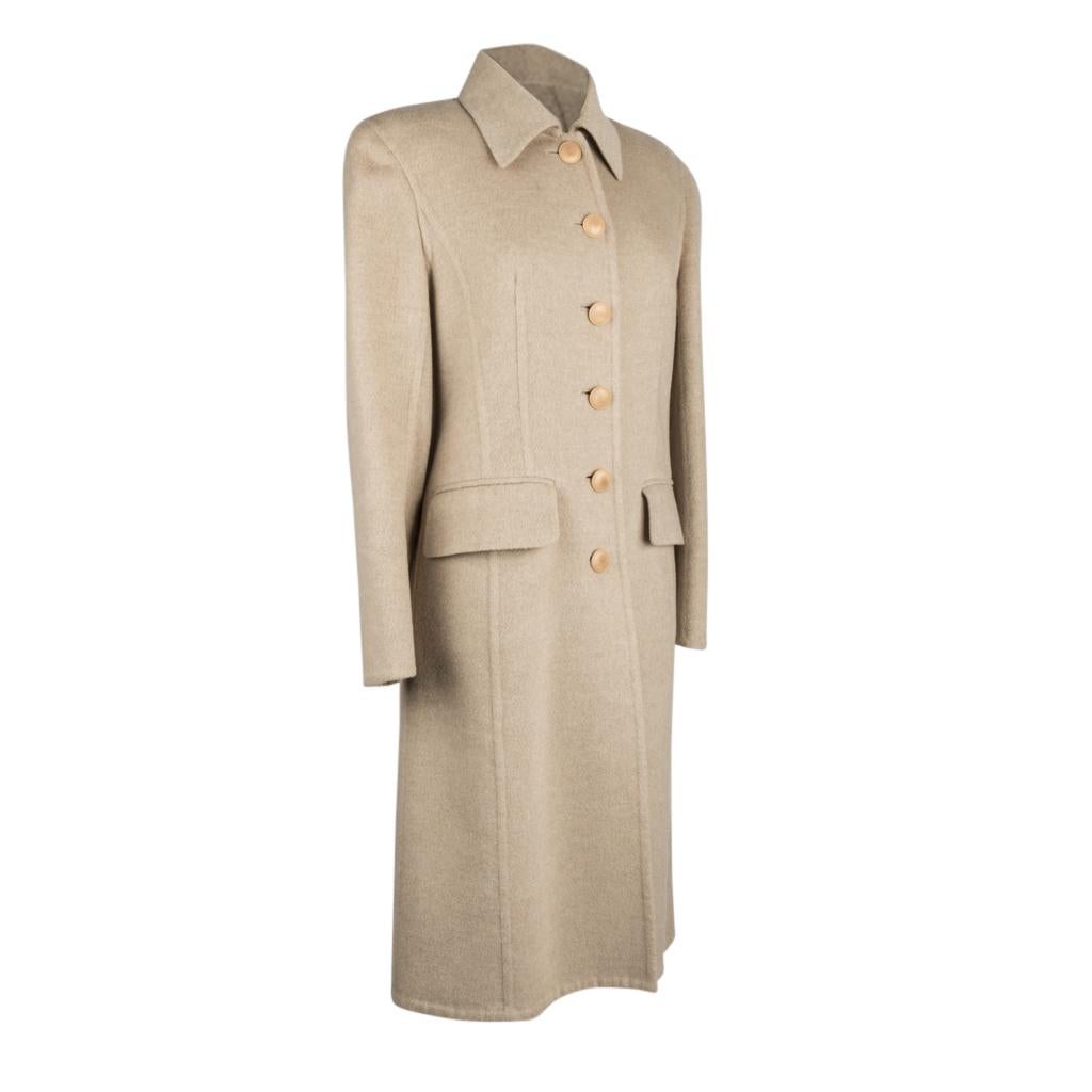 Guaranteed authentic Hermes classically styled vintage cashmere coat. 
Oatmeal hue six button single breast with small forward pointed collar.
Buttons have subtle H embossed
Two flap pockets.
Rear inverted pleat.
Piping detail throughout accents the