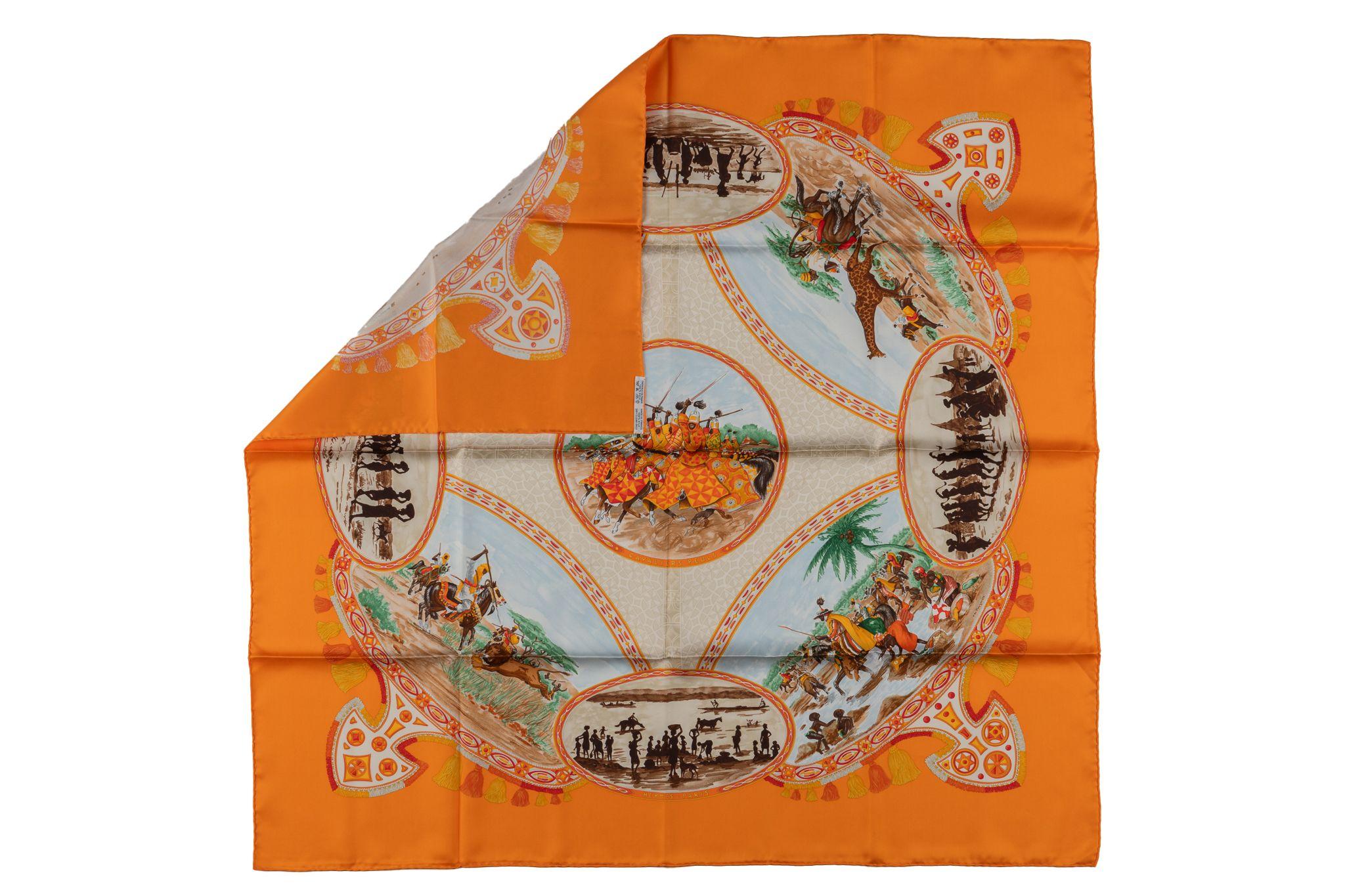 This Hermès “CAVALIERS PEULS” Horsemen of Western Africa scarf was designed by Jean de Fougerolle. Multi-color with orange background. It is made from 100% silk and hand-rolled edges. It comes with no box.