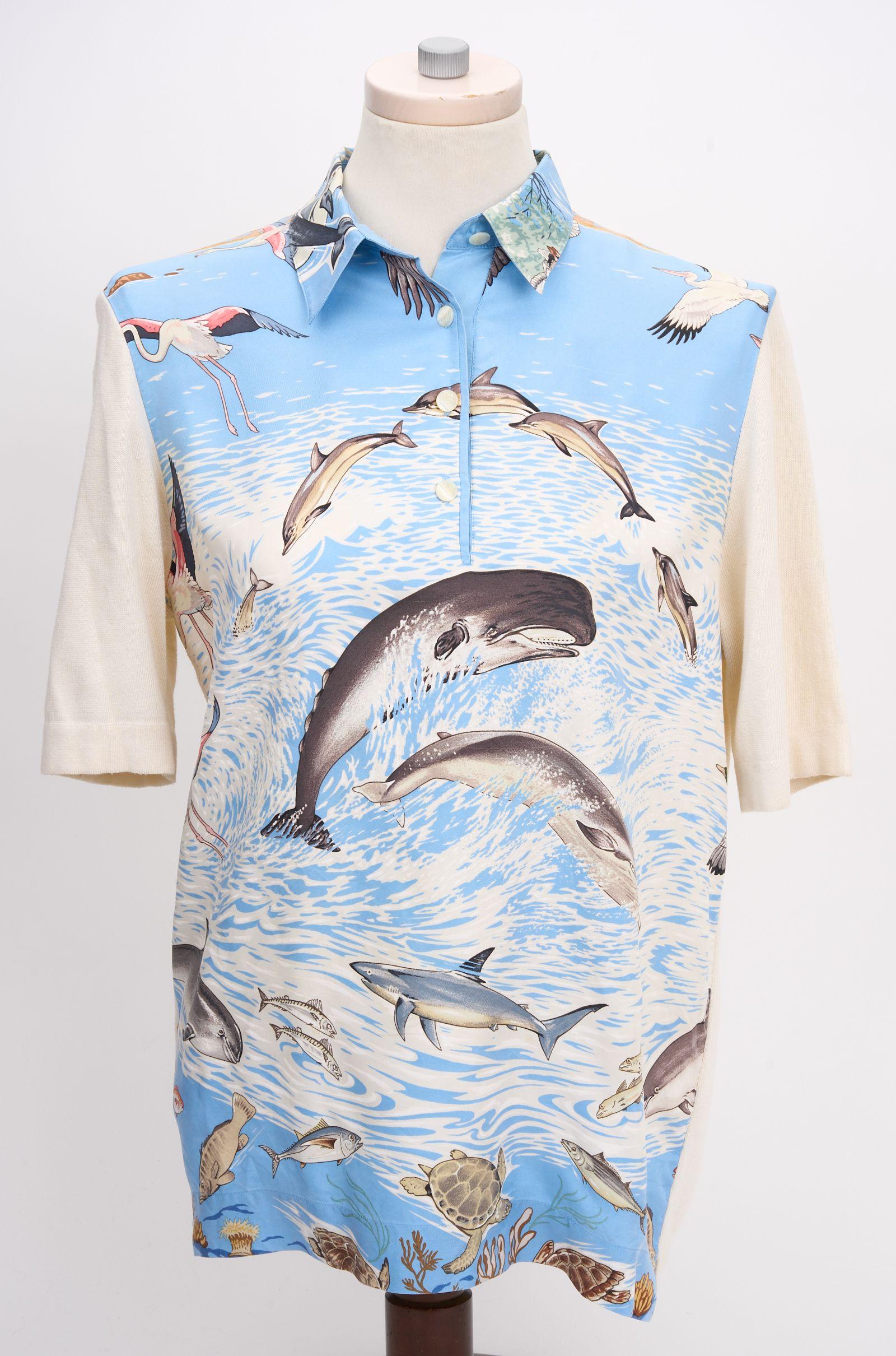 This Hermès Silk Print Polo features a collred neck with three buttons down the front, and a sea life print down the front. The arms and back are made from cashmere. Size S

Shoulder - 6