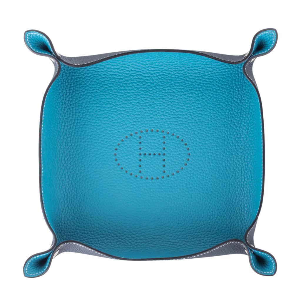 Guaranteed authentic Hermes Mises et Relances change tray with perforated Evelyn H.
Beautifully crafted in Clemence leather in Turquoise and Blue Abyss.
Nickelled clou de selle snaps.
A beautiful desk or bedroom accessory.
Stamped Hermes Made in