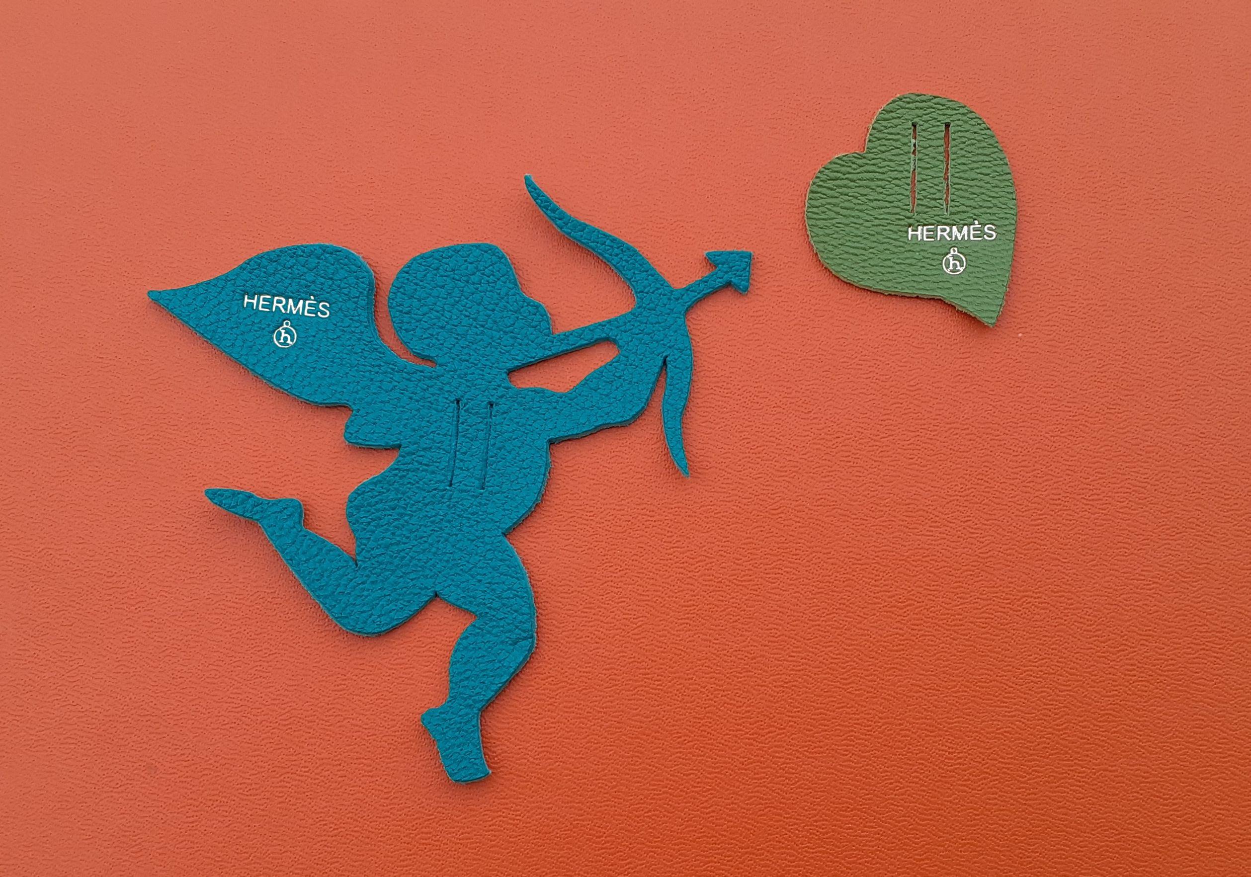 Please note: Cupid may appear blue. It is in fact lawn green

Shapes: Cupid and Heart

From the Petit h collection

Made of leather

Colorway: lawn green / anise green

These charms adorned the packaging of a small h item, so it has only one