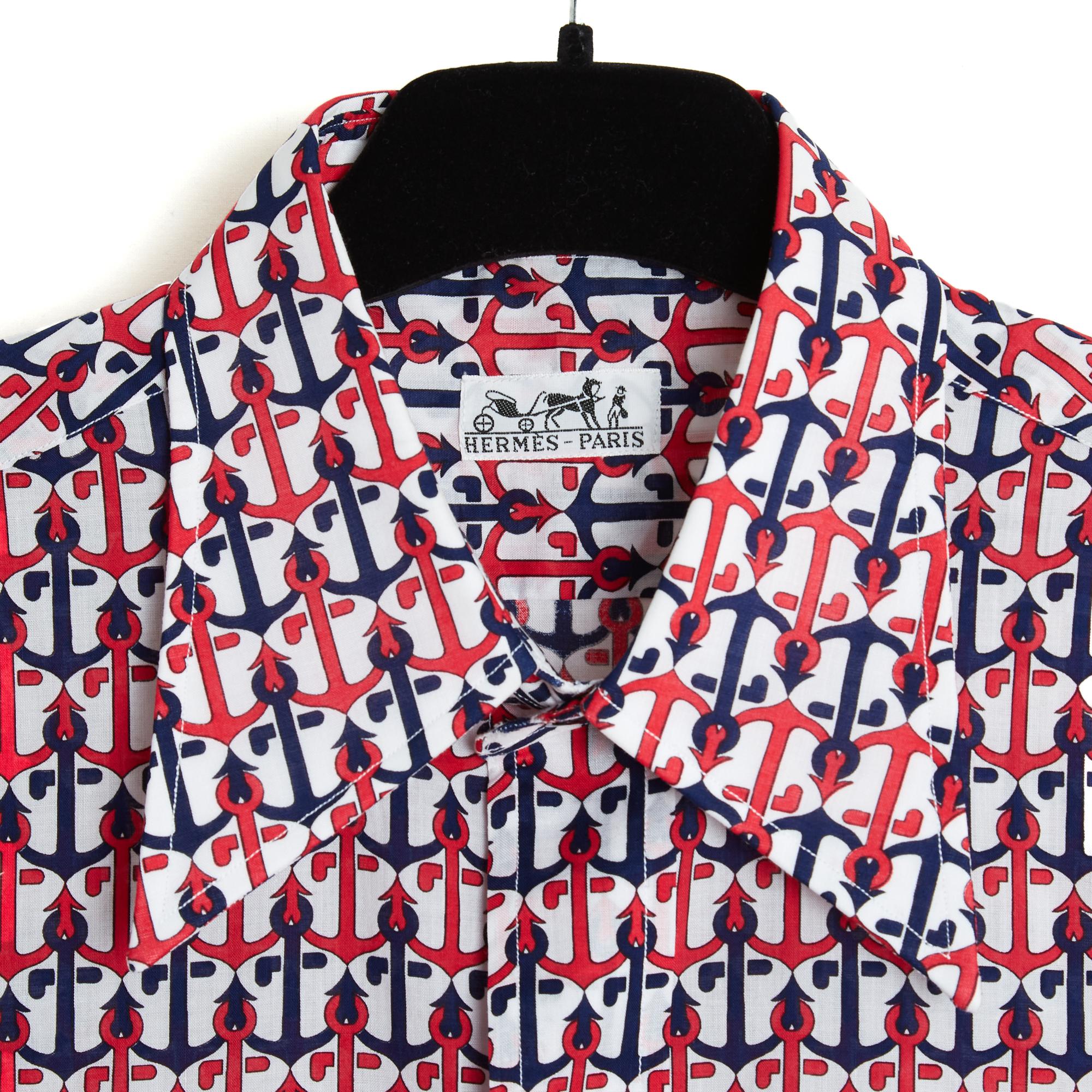 Hermès shirt in white cotton poplin printed with anchor chain pattern in red and navy blue, shirt collar closed in front by 6 buttons, long sleeves closed by a button, 2 slits on each side. No more size label but the measurements seem to indicate a