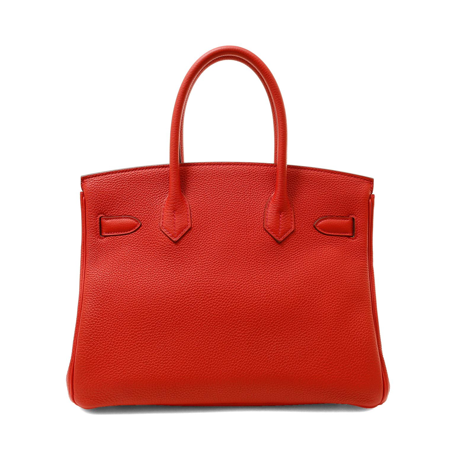 This authentic Hermès Cherry Red Togo 30 cm Birkin is in pristine unworn condition with the protective plastic intact on the hardware.  Stunningly paired with warm gold hardware, this brilliant red Birkin adds pop to any collection.
Cherry red Togo