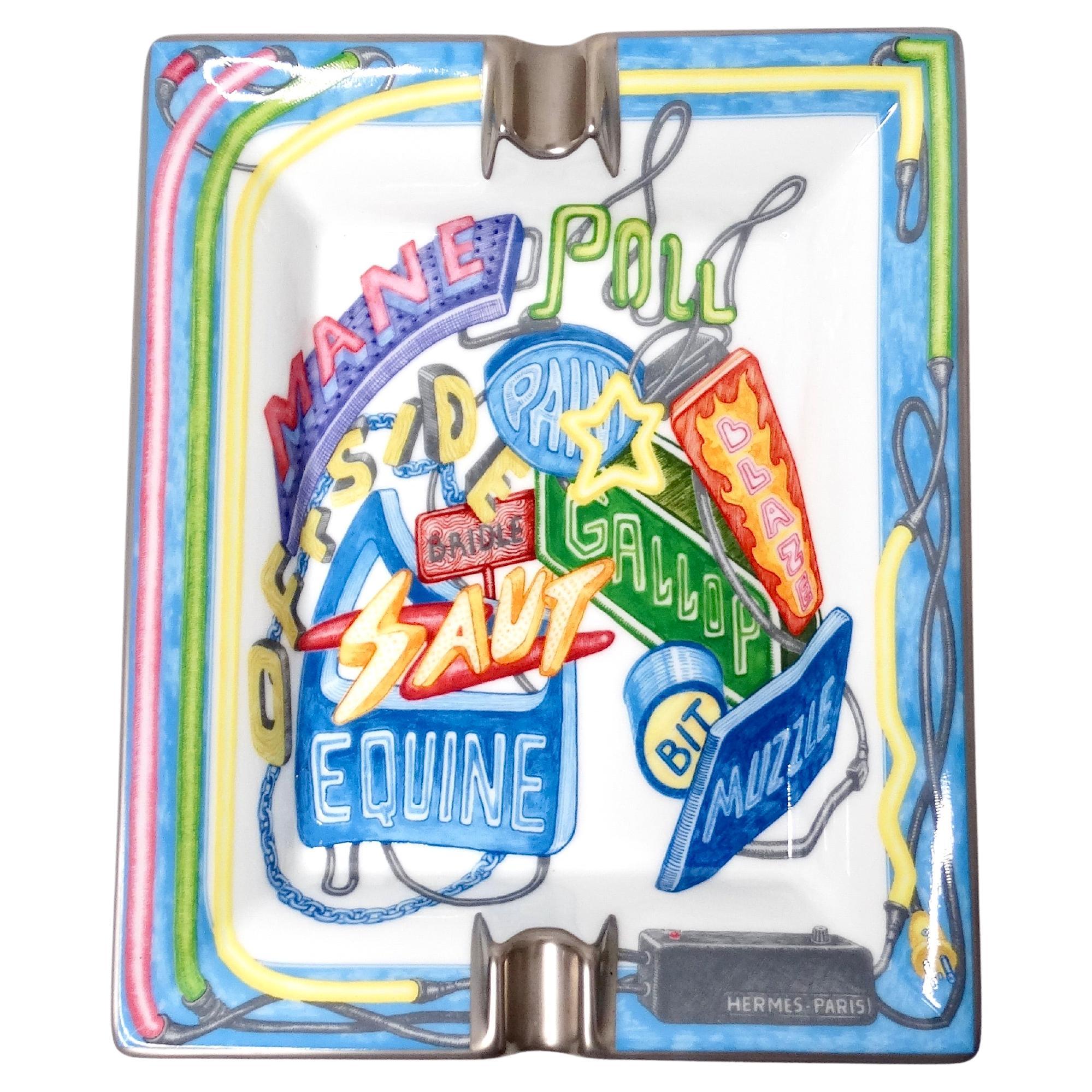 The Hermes Chevaloscope Neon Porcelain Ashtray is a luxurious and artistically crafted accessory that exemplifies opulence and intricate design. Handpainted with delicate platinum trim, the ashtray features a vibrant neon palette that accentuates