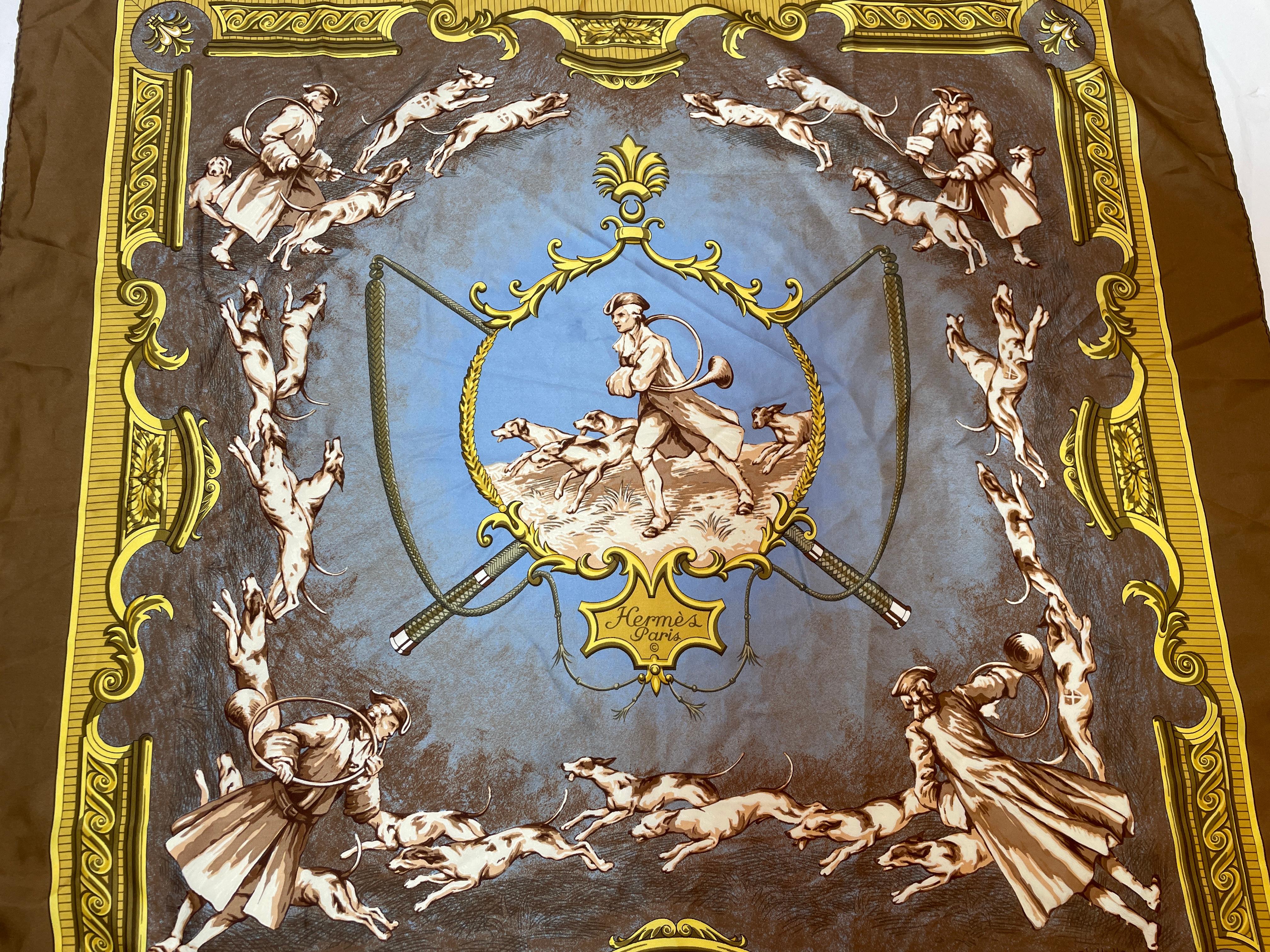 Hermes Chiens et Valets by Charles J. Hallo Silk Scarf 1963.
Gorgeous silk scarf carre Hermes in brown, blue and gold colors, featuring a 19th century period Royal French scene with Valets and Dogs in 
Very rare, Hermes silk scarf Chiens et Valets