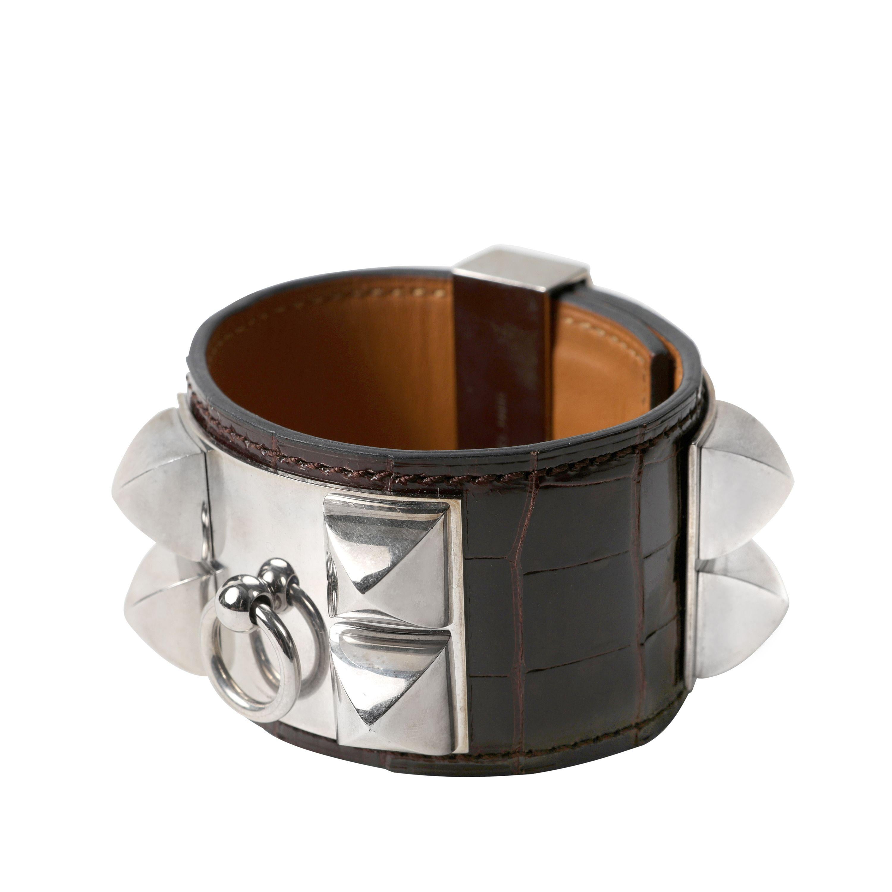 This authentic Hermès Chocolate Brown Alligator Collier de Chien Bracelet is in pristine condition.  The iconic Hermès CDC adds a chic bit of edginess to any ensemble.  Chocolate Brown alligator skin with Palladium Medor pyramid style studs and