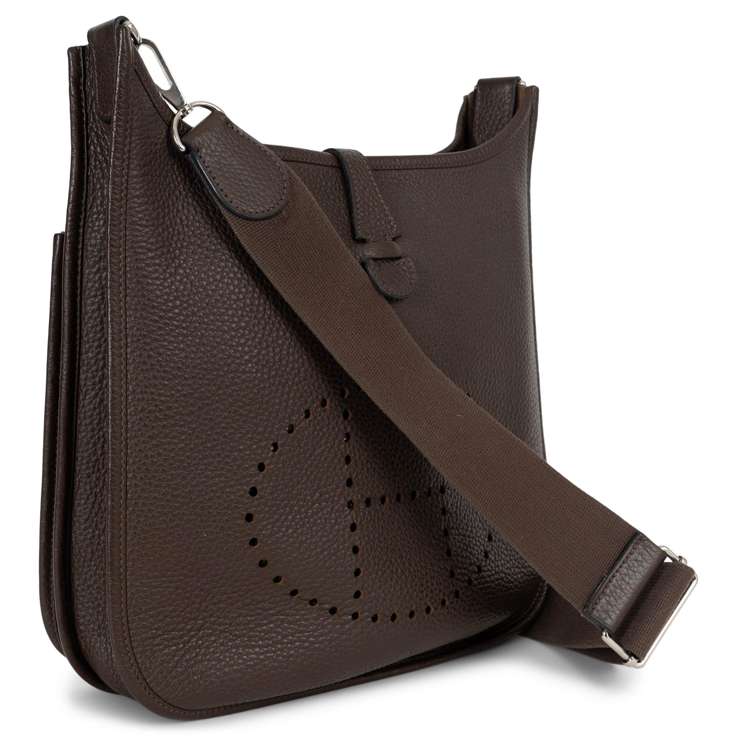 This 100% authentic Hermès Evelyne 29 crossbody bag in chocolate brown Taurillon Clemence leather embodies timeless elegance and practicality. Crafted from supple, grained Clemence leather, it features the iconic perforated 