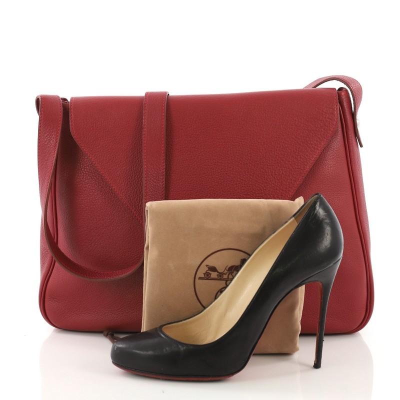 This Hermes Christine Handbag Leather, crafted in Rouge Vif red Clemence leather, features single loop leather strap, envelope style flap and Palladium hardware. Its flap opens to a Rouge Vif red Clemence leather interior with slip pocket. Date
