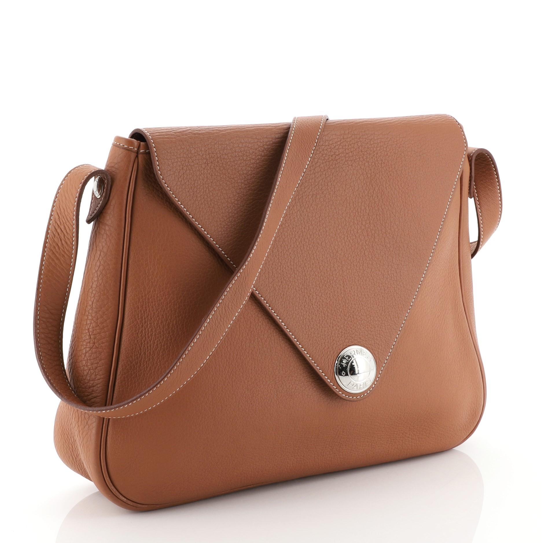 This Hermes Christine Handbag Leather, crafted in Etrusque brown Clemence leather, features single loop leather strap, envelope-style flap and palladium hardware. Its flap opens to an Etrusque brown Chevre leather interior with slip pocket. Date