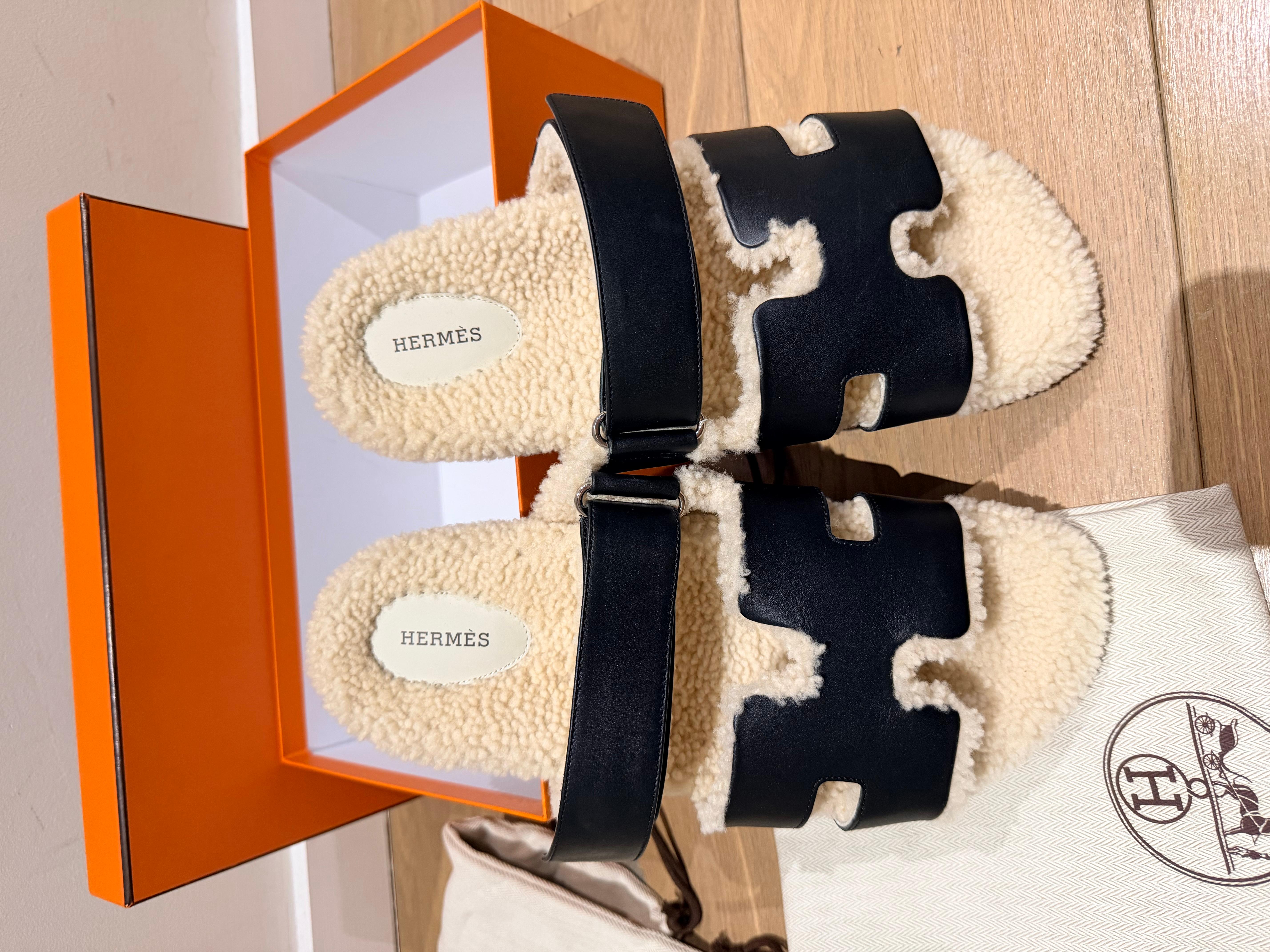 Sandales Hermes Chypre Black en cuir de veau avec doublure en shearling, semelle anatomique en caoutchouc et bride réglable.
Un design élégant pour un look confortable et décontracté.
Taille 44 dans sa boîte et ses sacs à poussière.