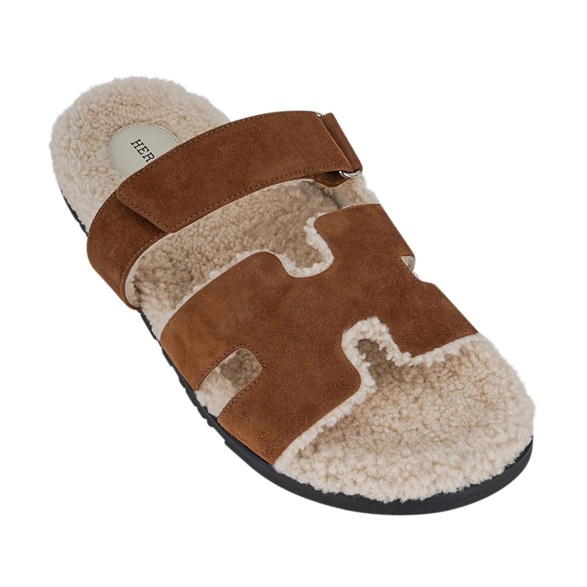 Mightychic offers a limited edition Hermes Men's Brun Fume and Ecru Chypre Veau Indios Woolskin sandals featured in suede.
The iconic H cutout over the top of the foot in Doblis with ecru shearling insole and H embossed rubber sole.
Beautiful warm