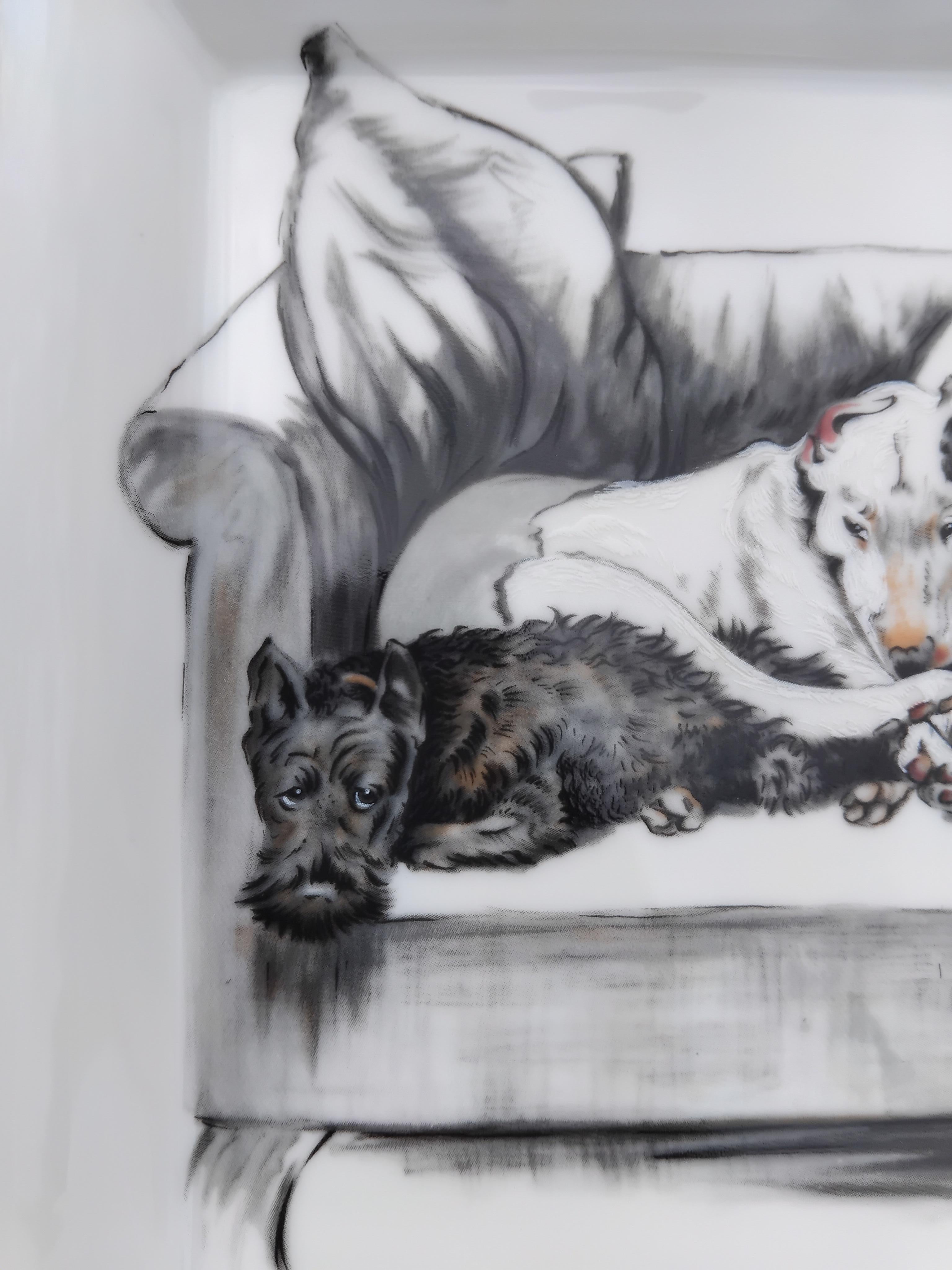 Seltener und liebenswerter authentischer Hermès Aschenbecher

Druck: 2 Hunde, die auf einem Sessel schlafen

Entworfen Cecil Aldin

Hergestellt in Frankreich

Aus bedrucktem Porzellan, Ränder und Kerben handbemalt mit Platin (silberfarben)

Sockel