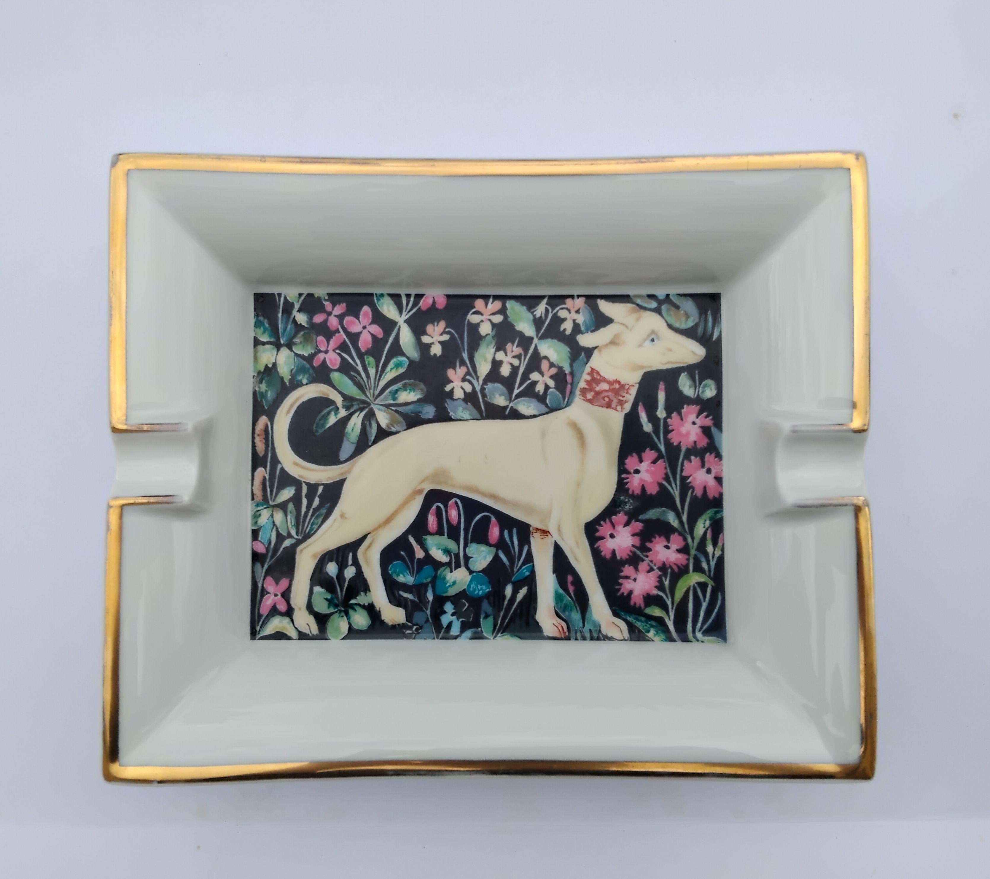 Rare and Beautiful Authentic Hermès Ashtray

Print: greyhound dog in a flower decor

Made in France

Vintage item

Made of porcelain, edges gilded with fine gold, bottom covered with brown leather

Colorways: White, Beige, Blue, Pink,