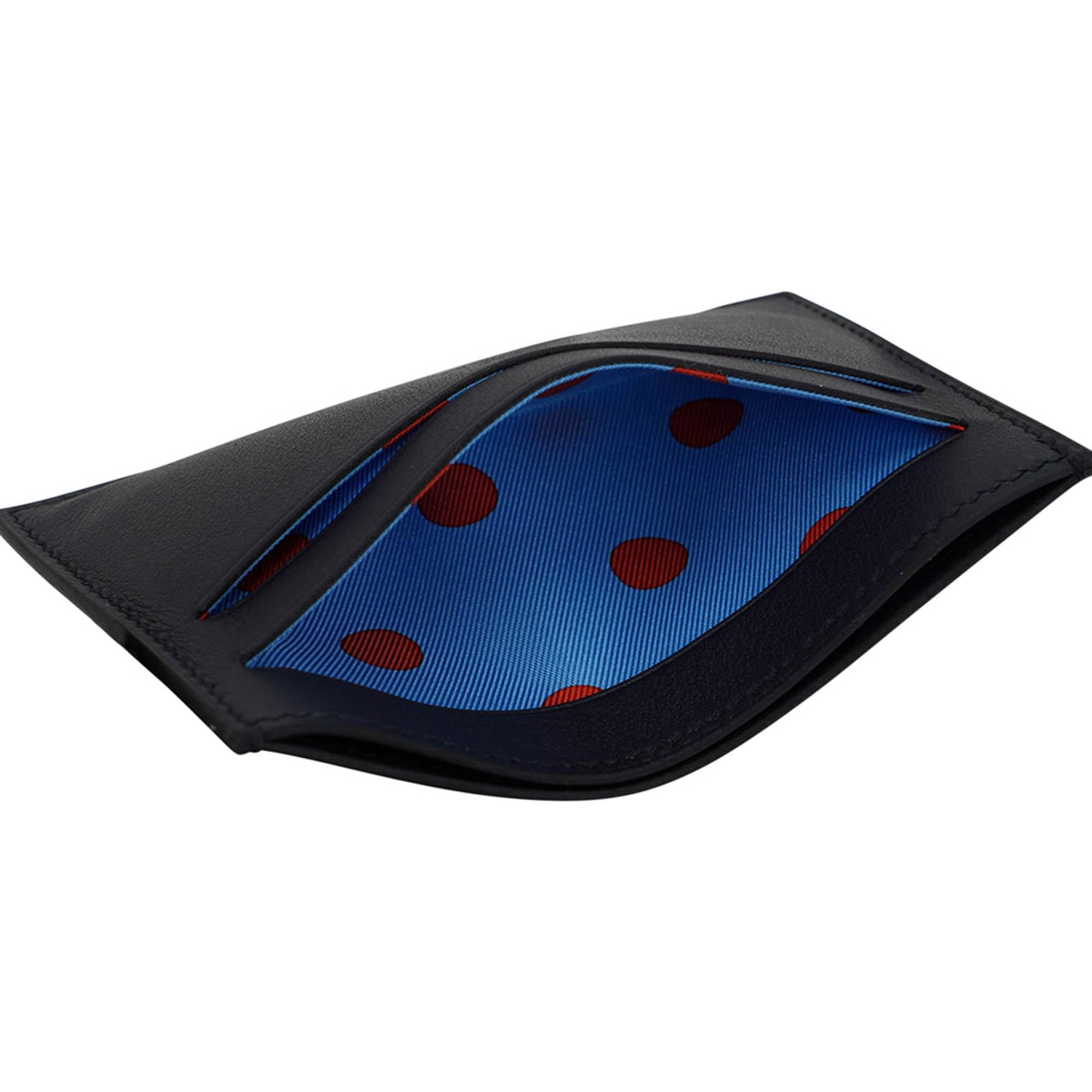Mightychic propose un porte-cartes Hermes Citizen Twill en noir.
La doublure intérieure en soie imprimée est d'un bleu clair amusant avec des pois rouges.
Le porte-cartes comporte 2 fentes pour cartes de visite ou de crédit à l'avant et 2 fentes à