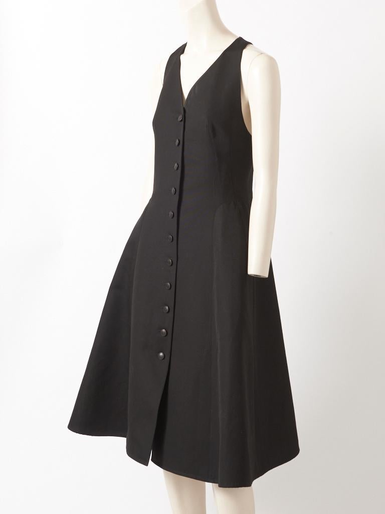Hermès, black cotton day dress, having a sculpted, silhouette, at the hips, with pockets, a racer back, a deep V neck and central front button closure. 