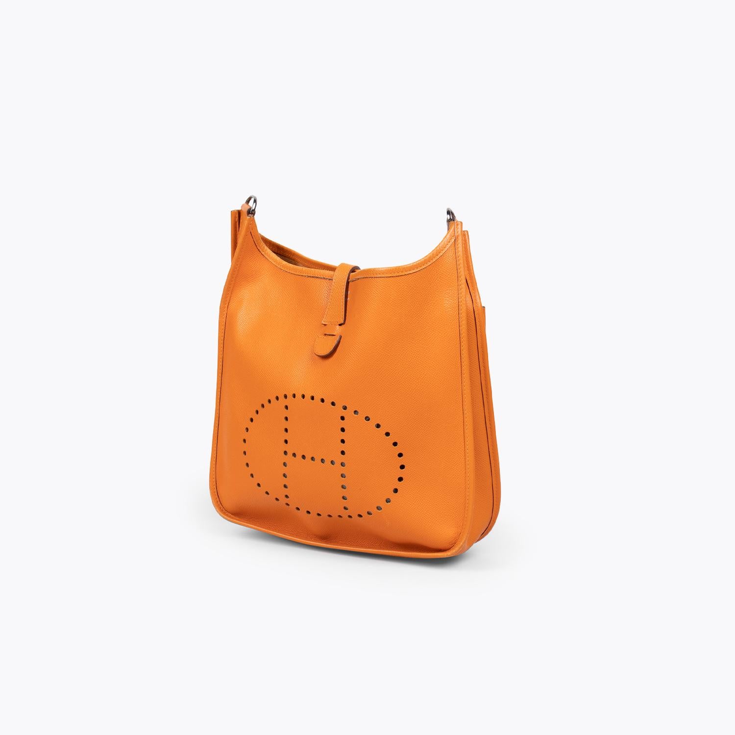 Terre Battue Clemence Hermès Evelyne II PM with

– Palladium-plated hardware
– Single optional adjustable flat shoulder strap
– Perforated logo detail at front face
– Single slip pocket with snap closure at back, tonal suede lining and snap closure