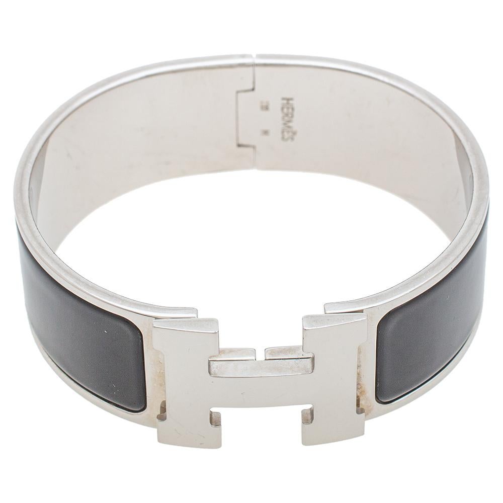 Adorn your wrist with this stunner of a bracelet from Hermès. The piece is from their Clic Clac H collection and it has been crafted from palladium-plated metal and designed with black enamel. This bracelet is complete with the iconic H. Get those