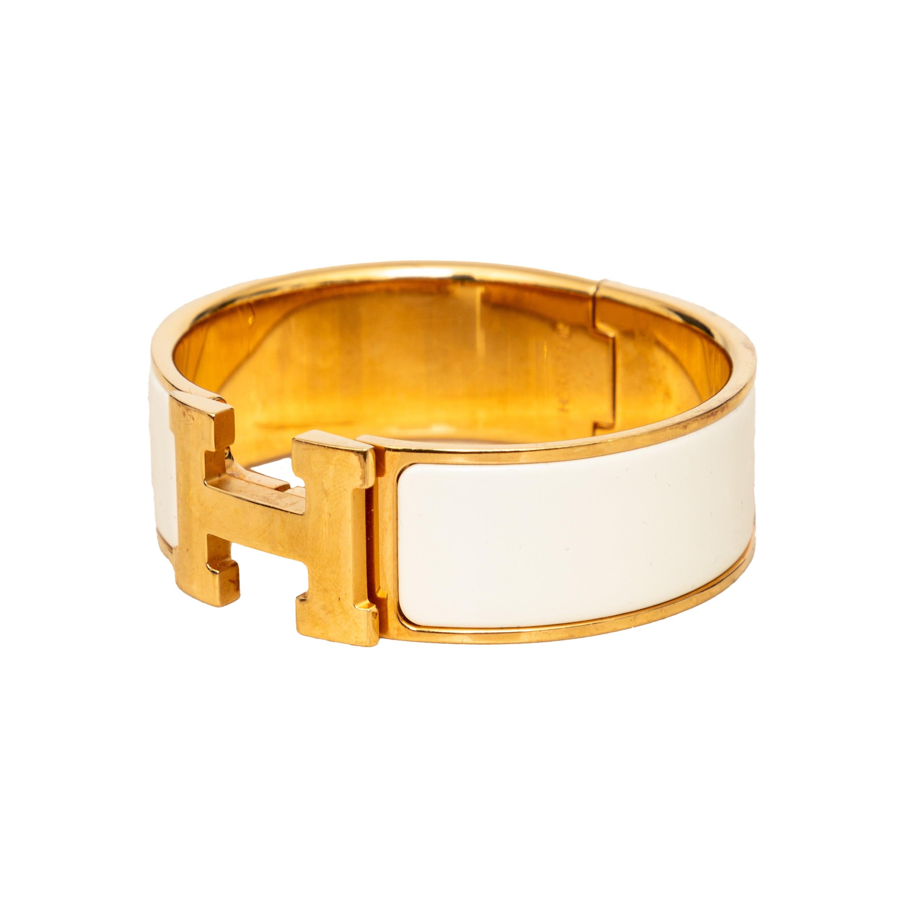 Upgrade your accessory game with the Hermès Clic Clac H Bracelet. This bangle style bracelet in plain white enamel is both elegant and versatile. Its ingenious toggle clasp allows for easy opening and closing, revealing a striking 