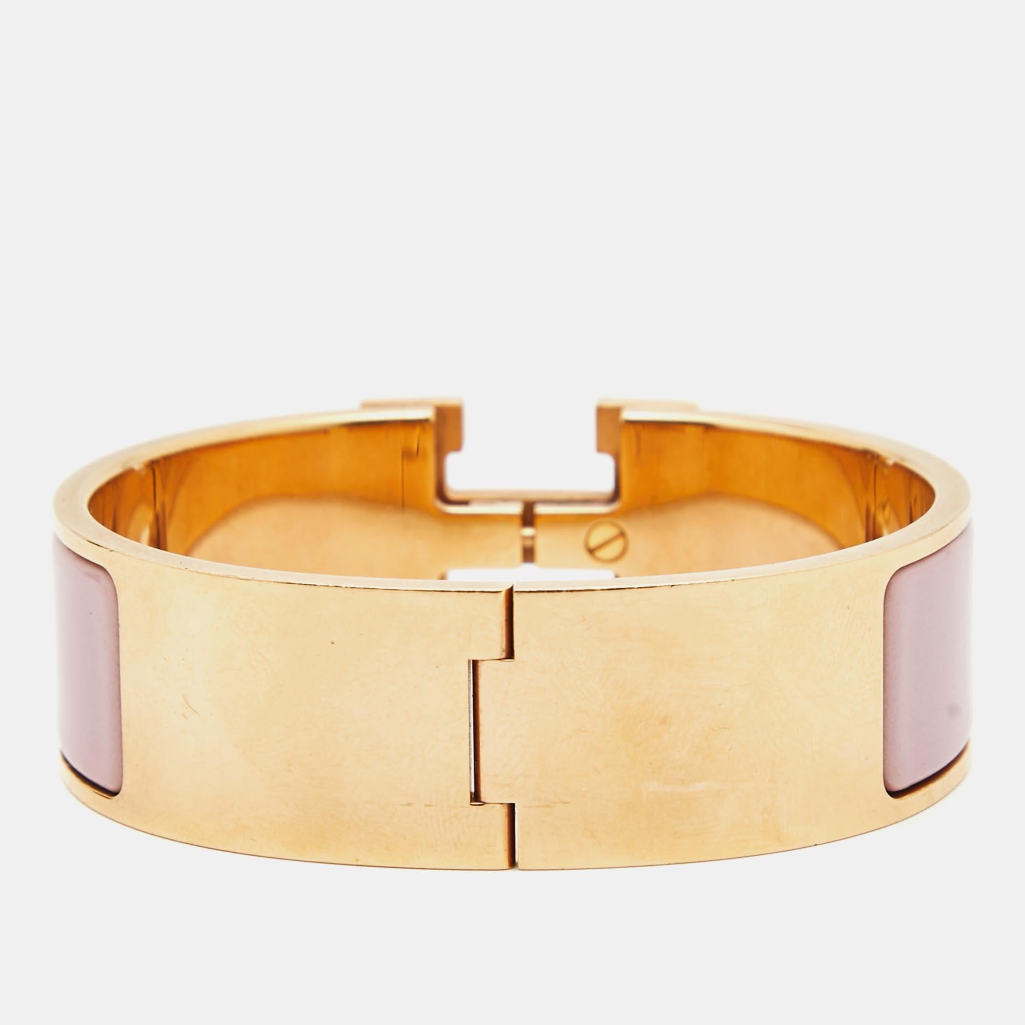 The Hermès Clic Clac H bracelet is an exquisite piece of jewelry. It features a glossy enamel band with a prominent gold-plated H-shaped clasp, creating a striking contrast. This luxurious and elegant accessory embodies timeless style and