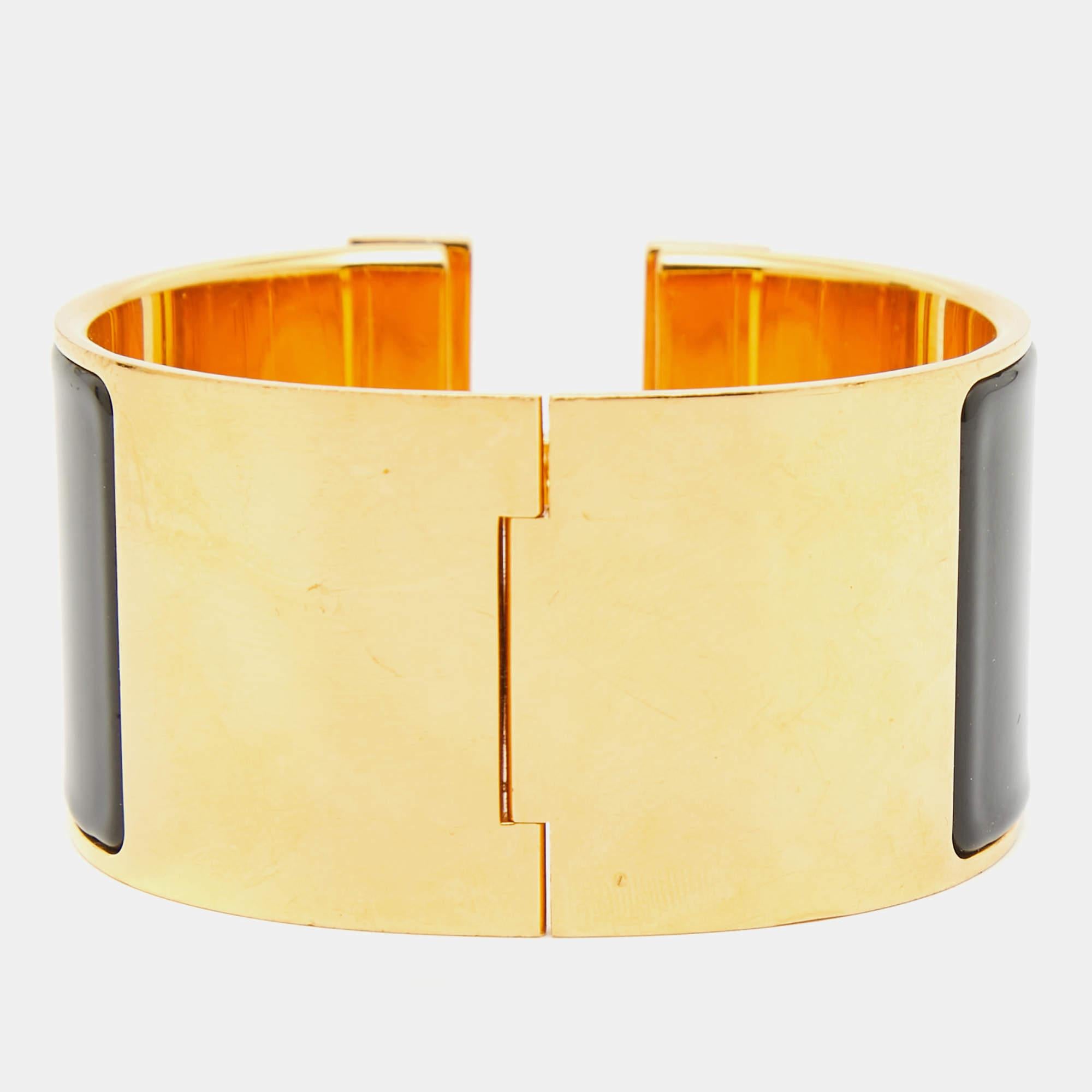 The Hermès Clic Clac H bracelet is an exquisite piece of jewelry. It features a glossy enamel band with a prominent gold-plated H-shaped clasp, creating a striking contrast. This luxurious and elegant accessory embodies timeless style and