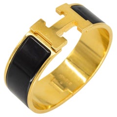 Hermès "Clic Clac" H Gold Plated Metal and Black Enamel Bracelet, 2011.