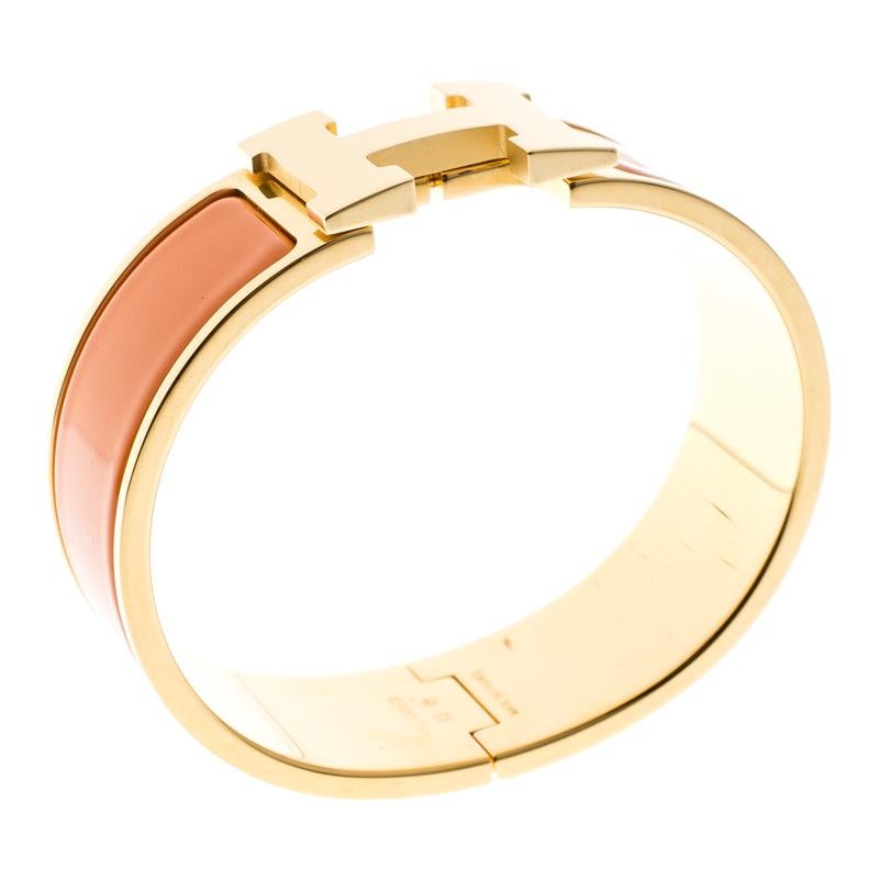 Adorn your wrist with this stunner of a bracelet from Hermes. The piece is from their Clic Clac H collection and it has been crafted from gold-plated metal and designed with orange enamel. This bracelet is complete with the iconic H. Get those