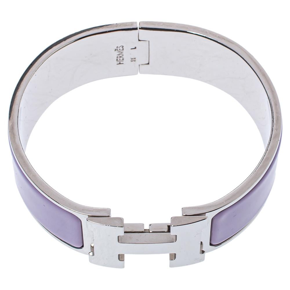 Adorn your wrist with this stunner of a bracelet from Hermes. The piece is from their Clic Clac H collection, and it has been crafted from palladium-plated metal and designed with lavender-hued enamel. This bracelet is complete with the iconic H to