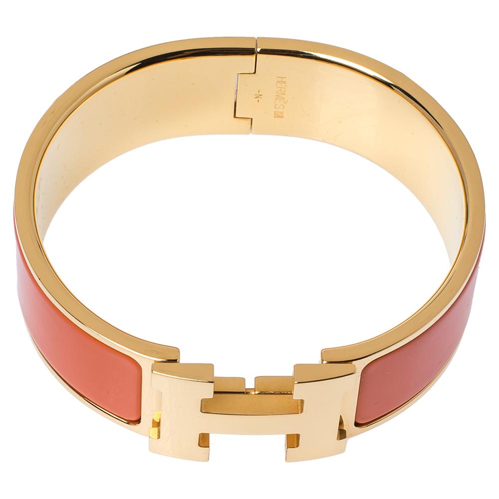 Adorn your wrist with this stunner of a bracelet from Hermès. The piece is from their Clic Clac H collection and it has been crafted from gold-plated metal and designed with orange enamel. This bracelet is complete with the iconic H. Get those